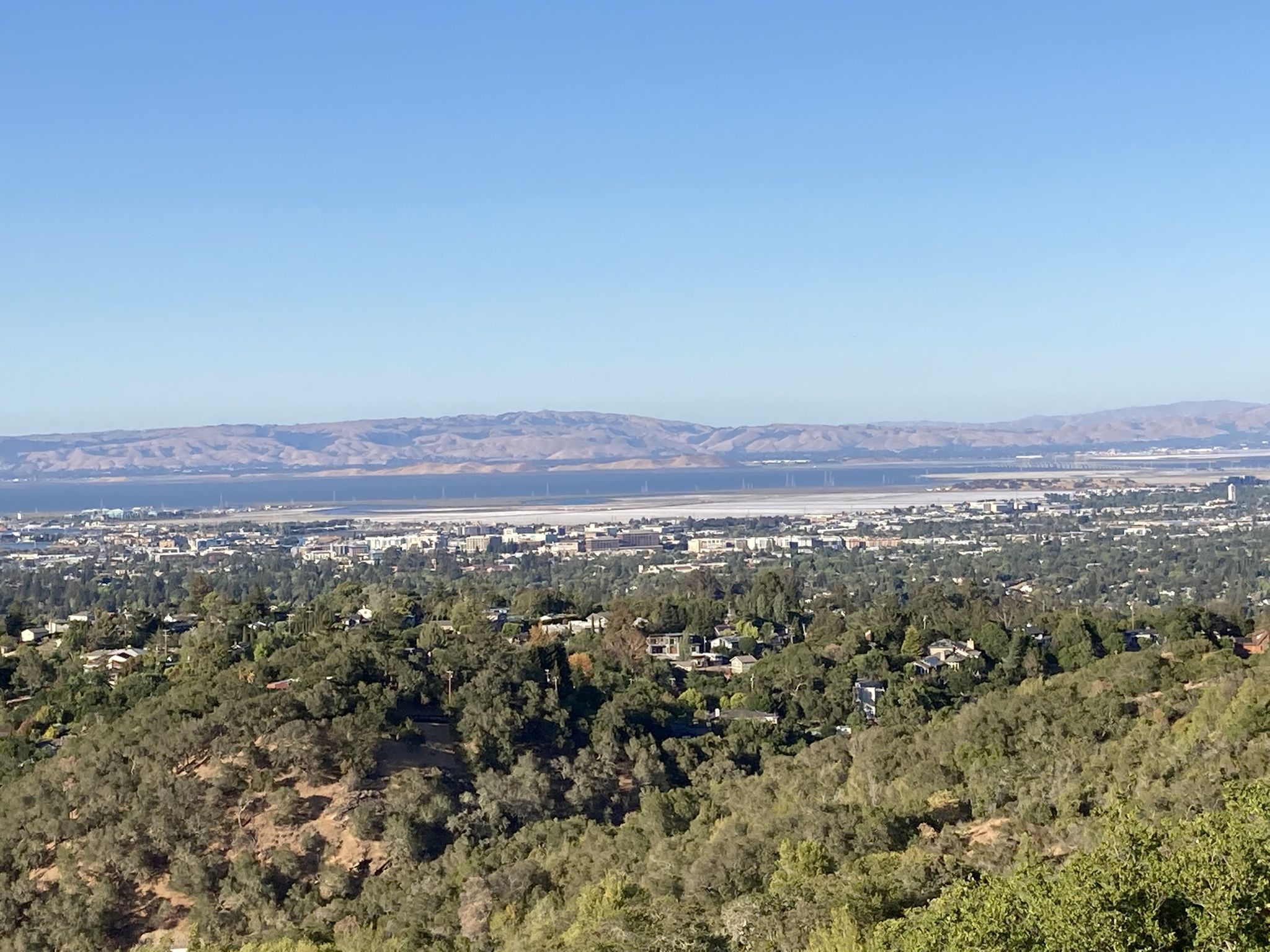 Panoramic view of a city, bay, and distant mountains under a clear blue sky. - Edgewood Trail Loop
