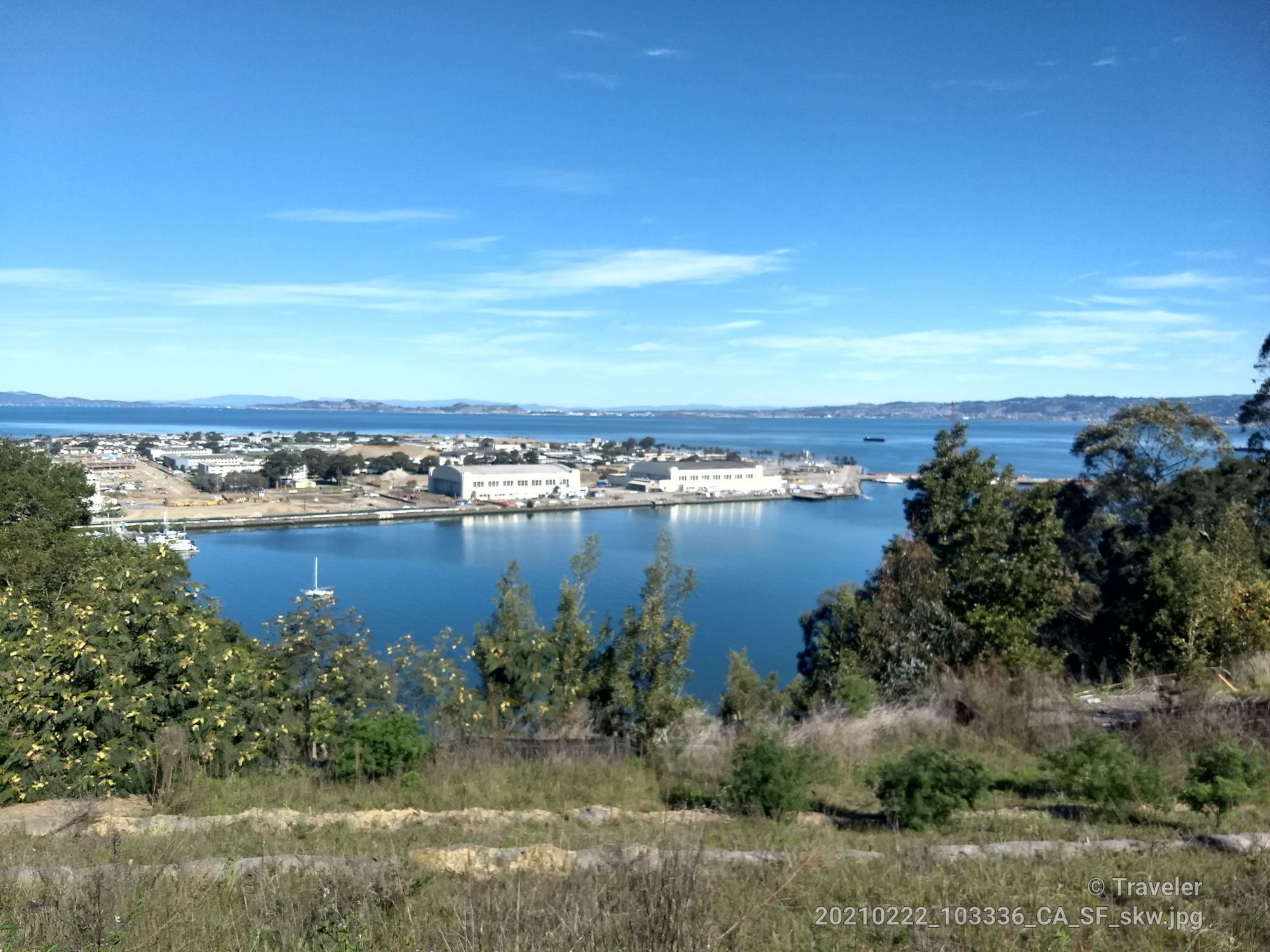Bay with buildings, distant land, and trees under a clear blue sky. - Summit of Yerba Buena Island – Alexander Zuckermann Path loop from North Berkeley