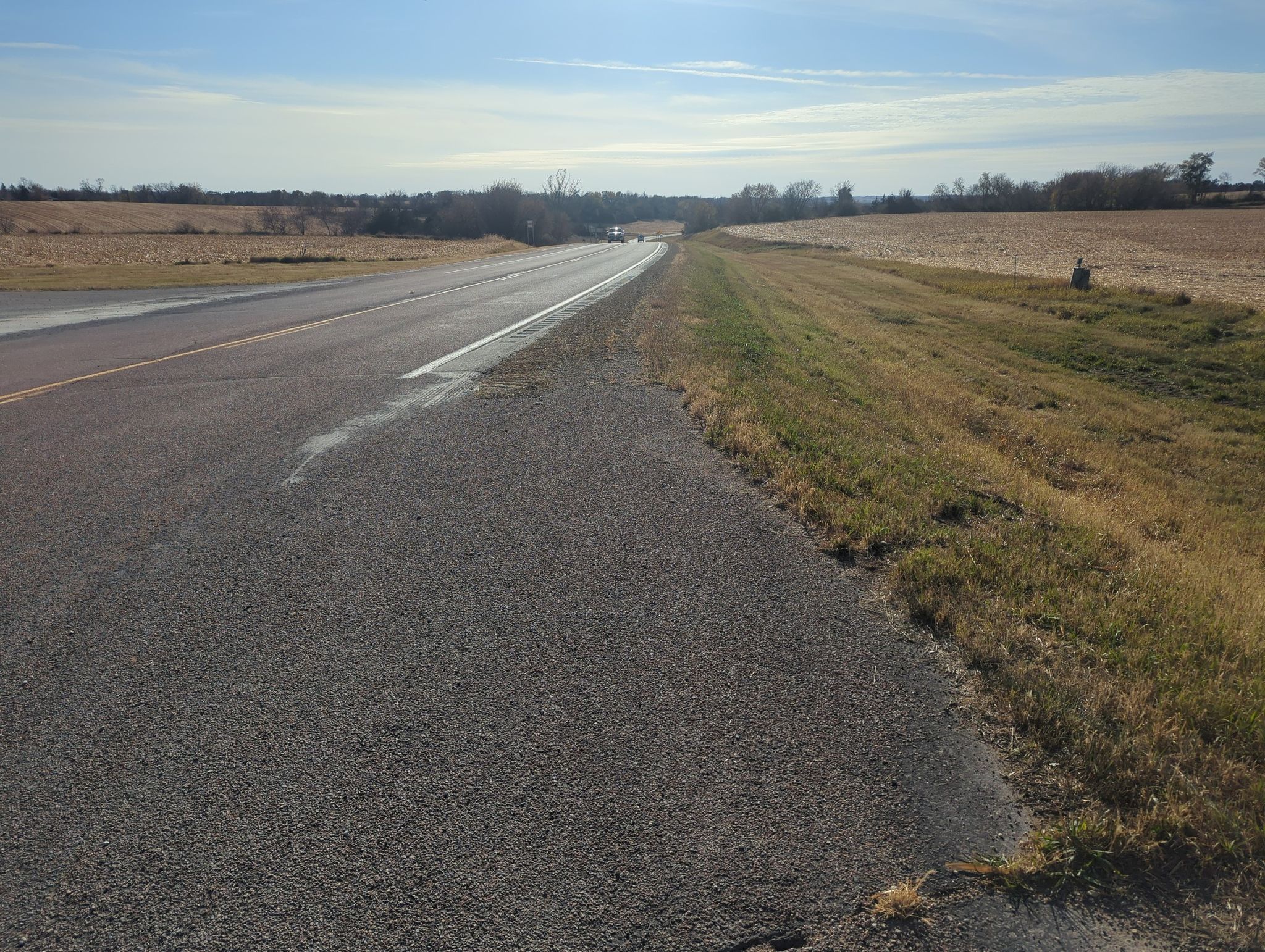 Paved road with dry fields on both sides under a bright, sunny sky. - Cannon River and Mississippi River loop