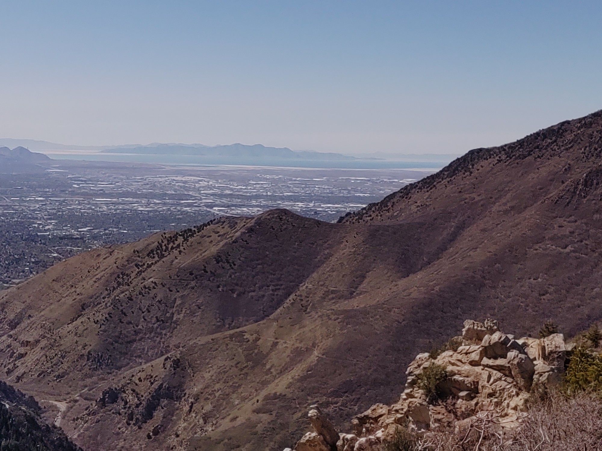 Sunny view of arid mountains overlooking a sprawling city under a clear sky. - Desolation Trail