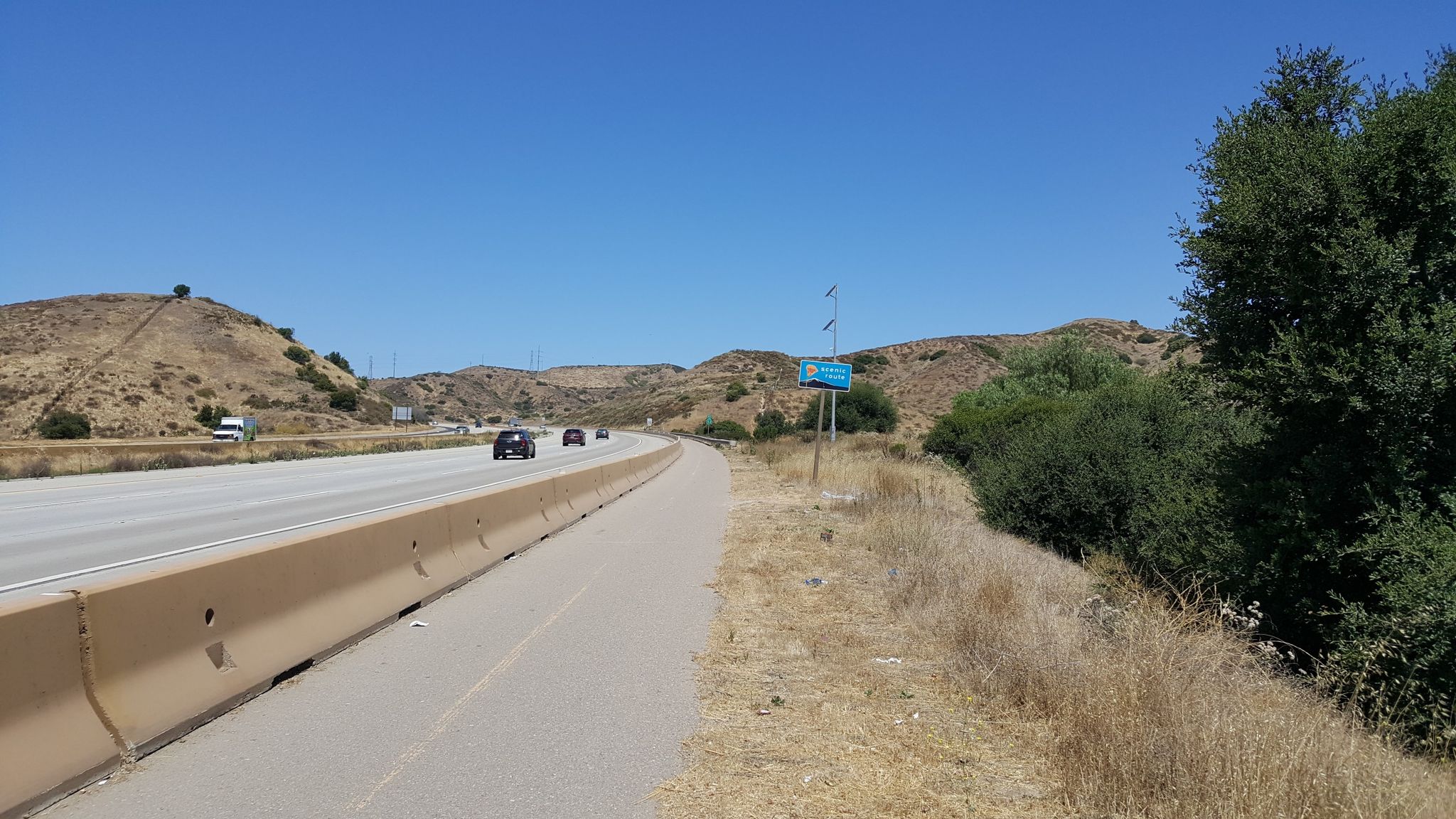Highway with cars, dry hills, and a clear blue sky on a bright day. - SR 52 Bike Path – Mission Trails Regional Park loop from San Carlos
