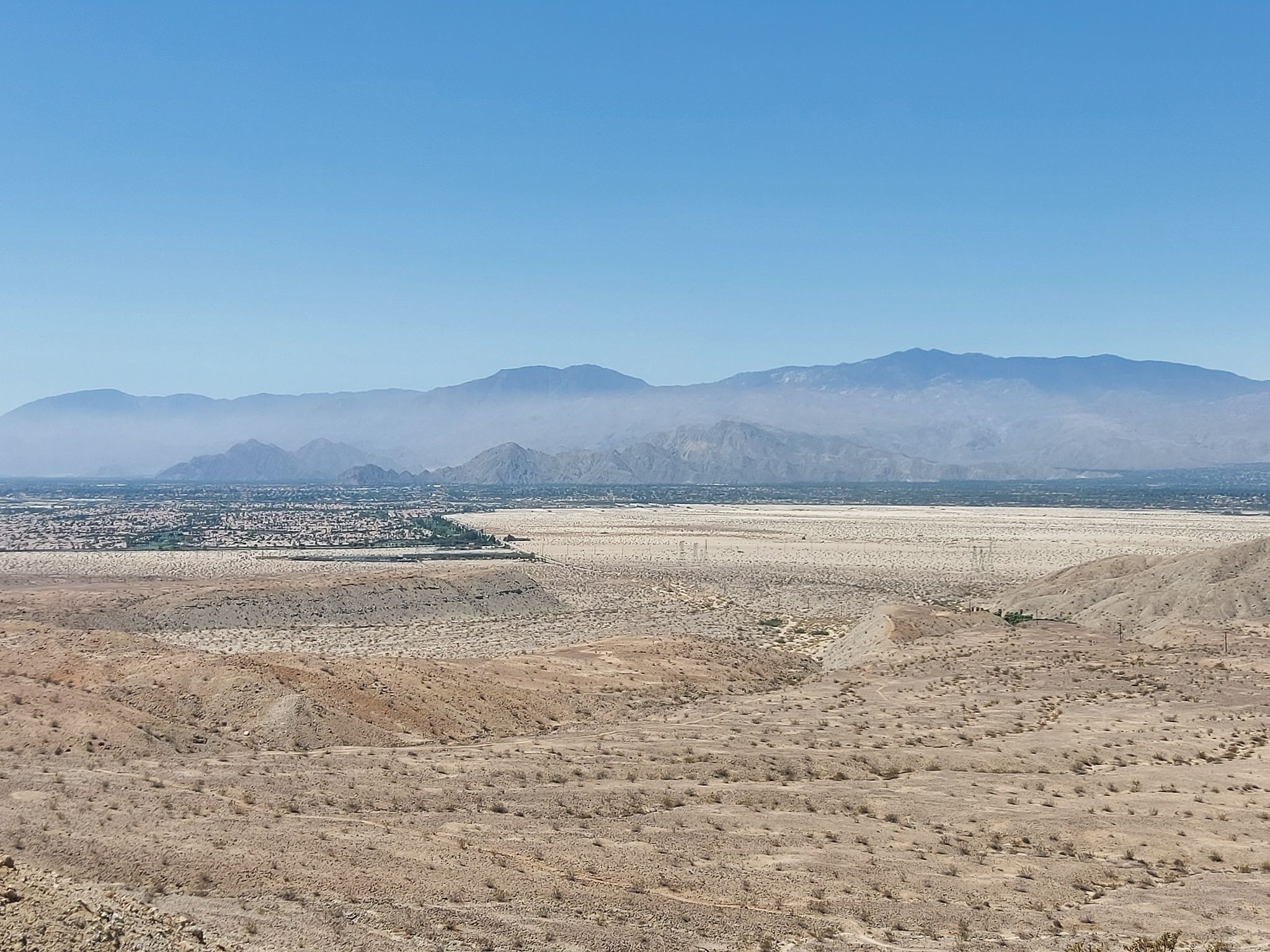 Expansive desert valley with distant mountains under a clear blue sky. - Pushwalla Palms Loop