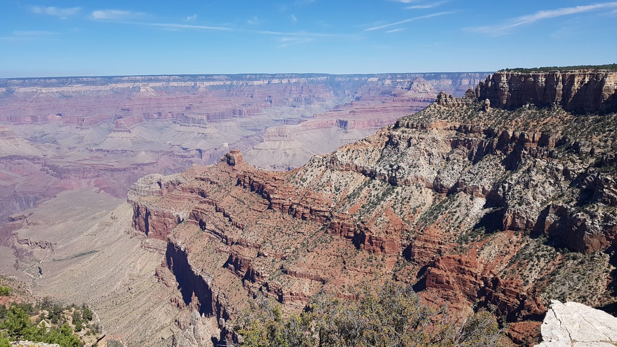 Wide view of a massive canyon with intricate rock layers and distant haze. - Grand Canyon Village, Yaki Point, and Grandview Point via Desert View Drive
