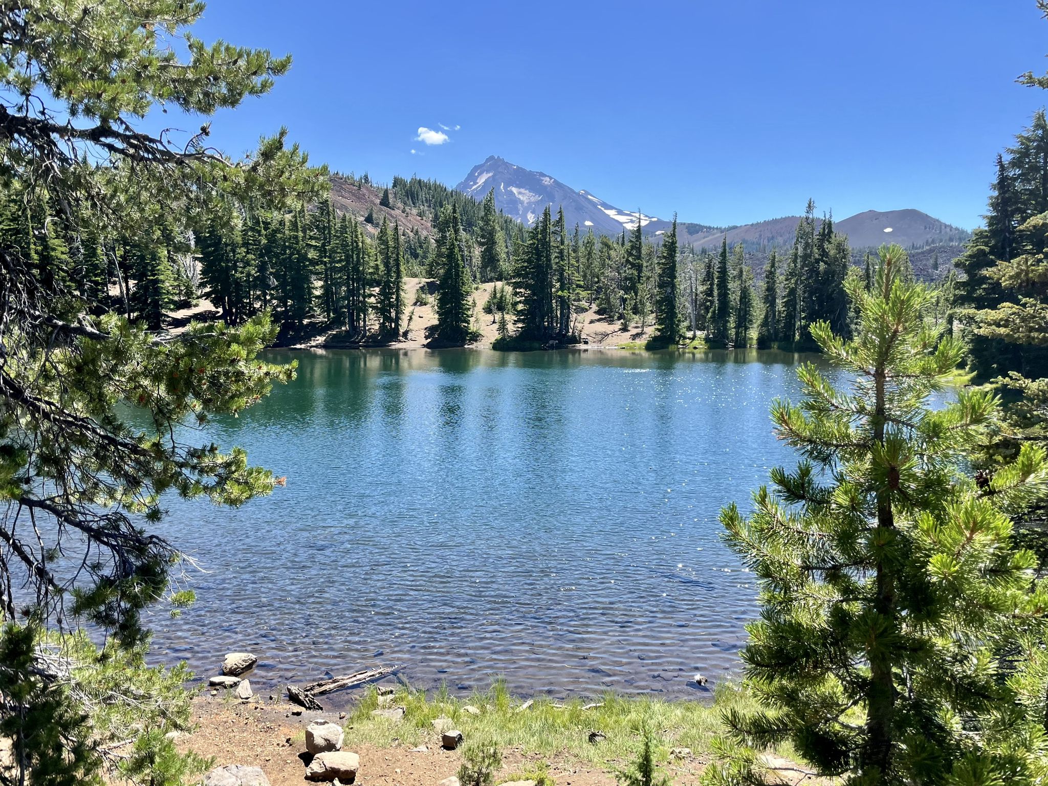 A serene lake framed by trees, with a snow-capped mountain in distance. - Matthieu Lakes Trail loop via North Matthieu Lake Trail Run