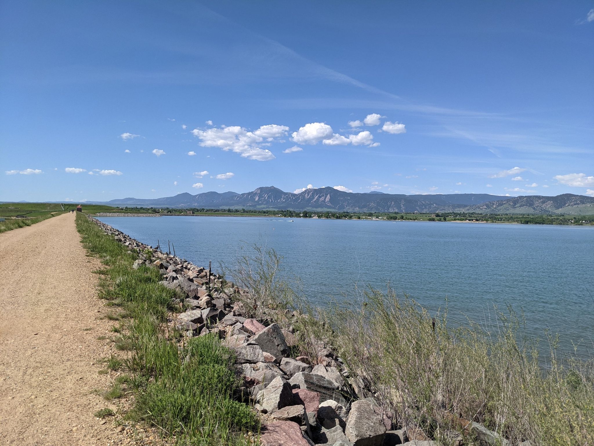 Dirt path next to a calm lake with distant mountains under a clear sky. - Longmont, Boulder Reservoir and Gunbarrel loop via the LOBO Trail