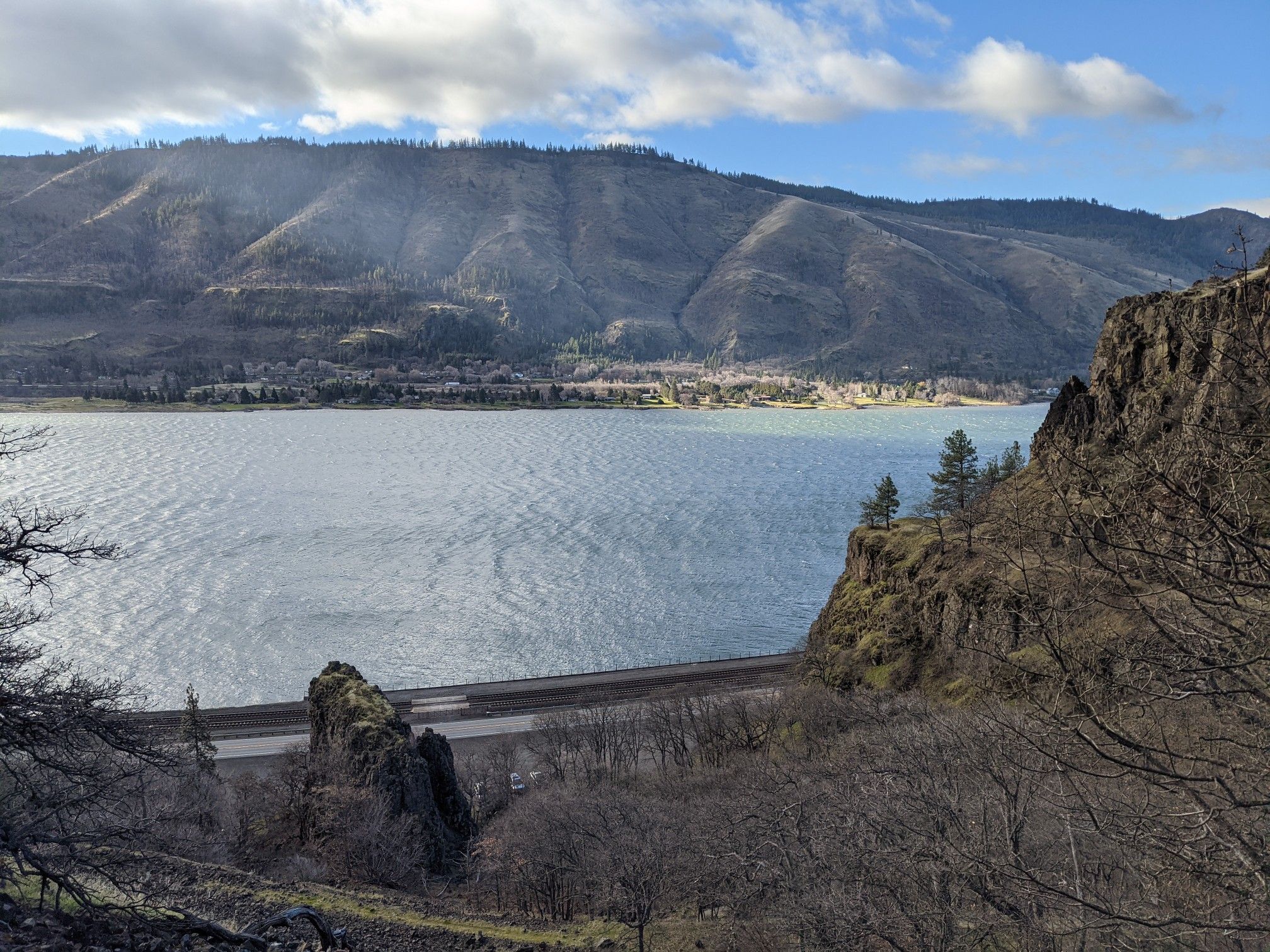 Wide view of a large lake, mountains, and a dam under a partly cloudy sky. - Lyle Cherry Orchard Trail