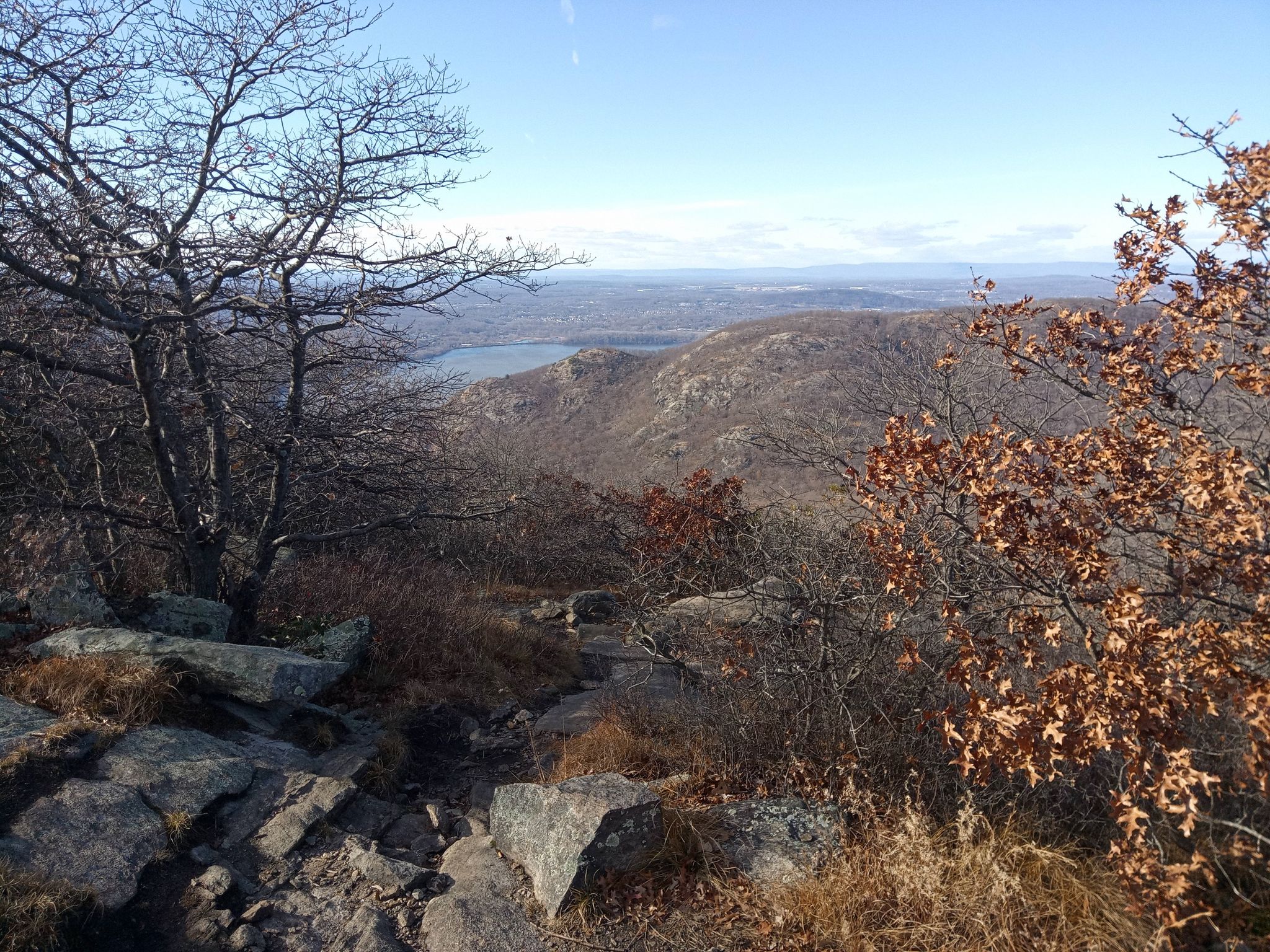 Rocky, barren hilltop with distant water and hills under a bright sky. - Bull Hill via Undercliff and Washburn Trails