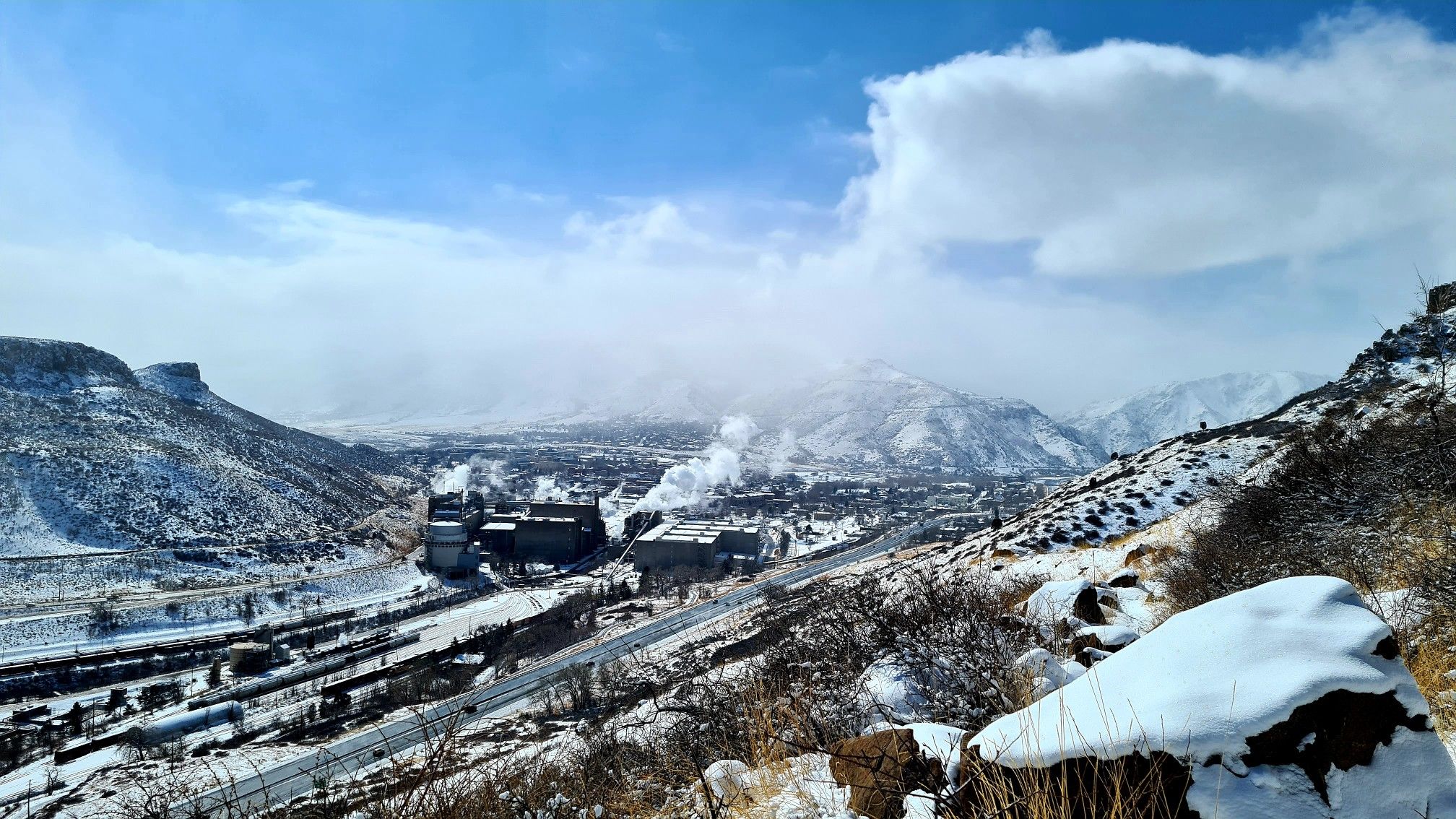 Snowy mountain valley with an industrial complex under a cloudy sky. - North Table Loop Trail