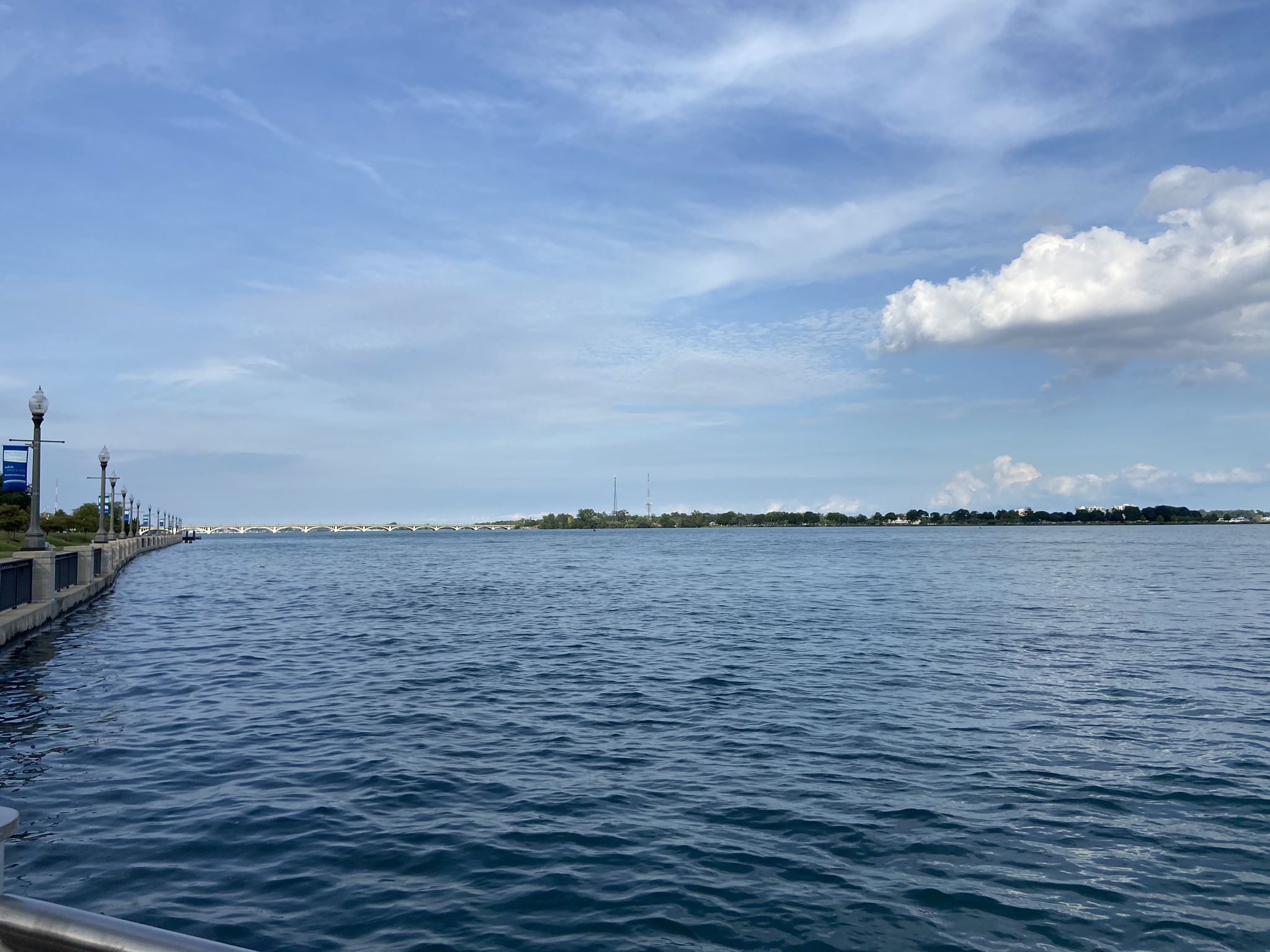 Wide river with distant shoreline under a bright, partly cloudy sky. - Iron Belle Trail: Belle Isle Loop