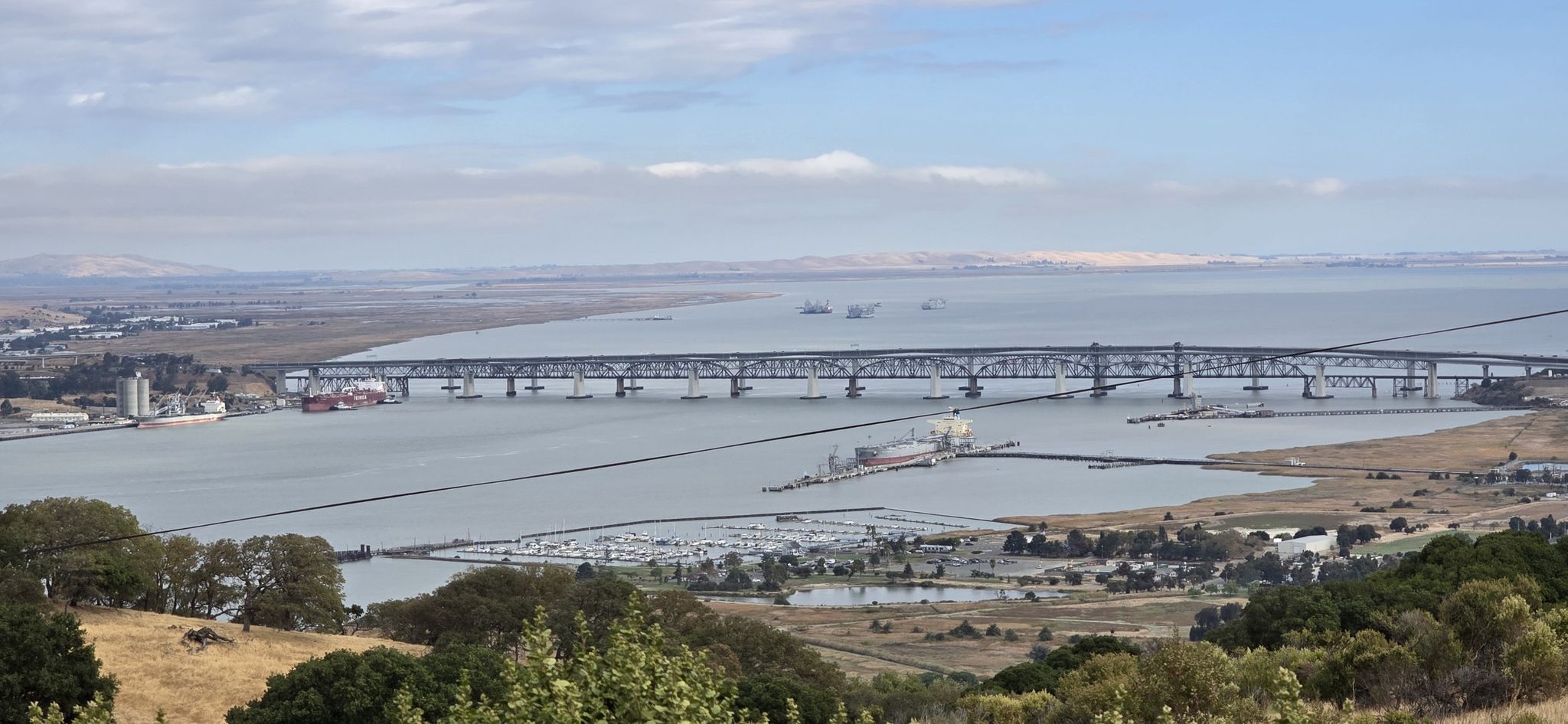 A long bridge spans wide water under a bright, partly cloudy sky. - Hulet Hornbeck and Franklin Ridge Loop