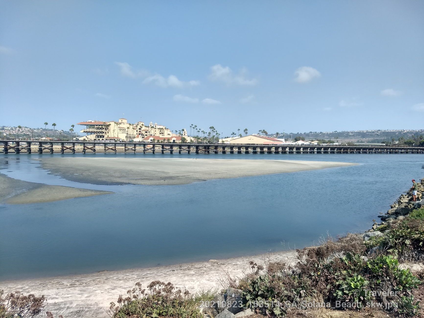 Sunny river view with a long wooden bridge and distant buildings. - Tunnel 4 Trail – Fire Road Switchback Viewpoint loop from Solana Beach