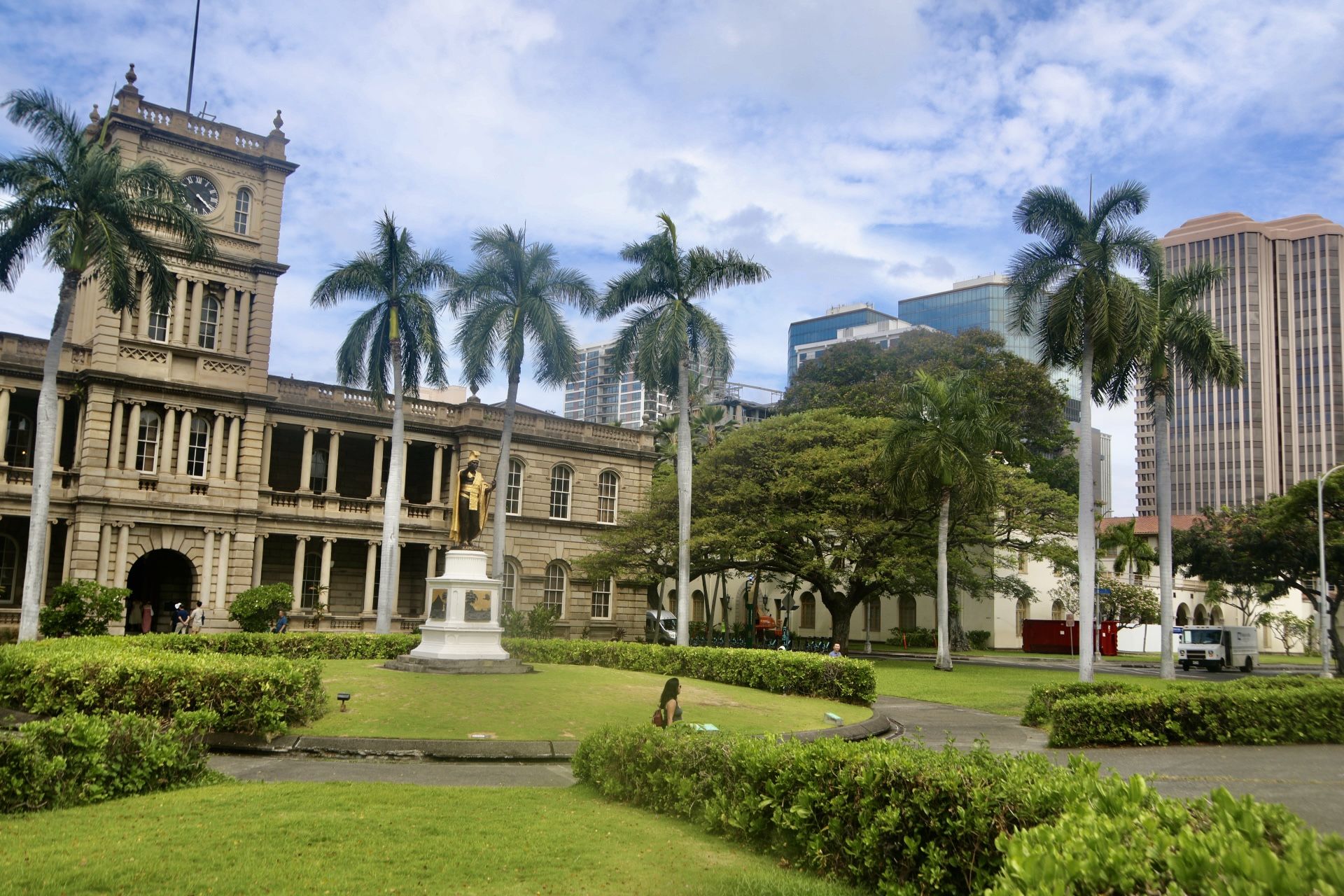 Historic building, green lawn, palm trees, statue, under a cloudy sky. - Giant fig tree – King Kamehameha Statue loop from Honolulu