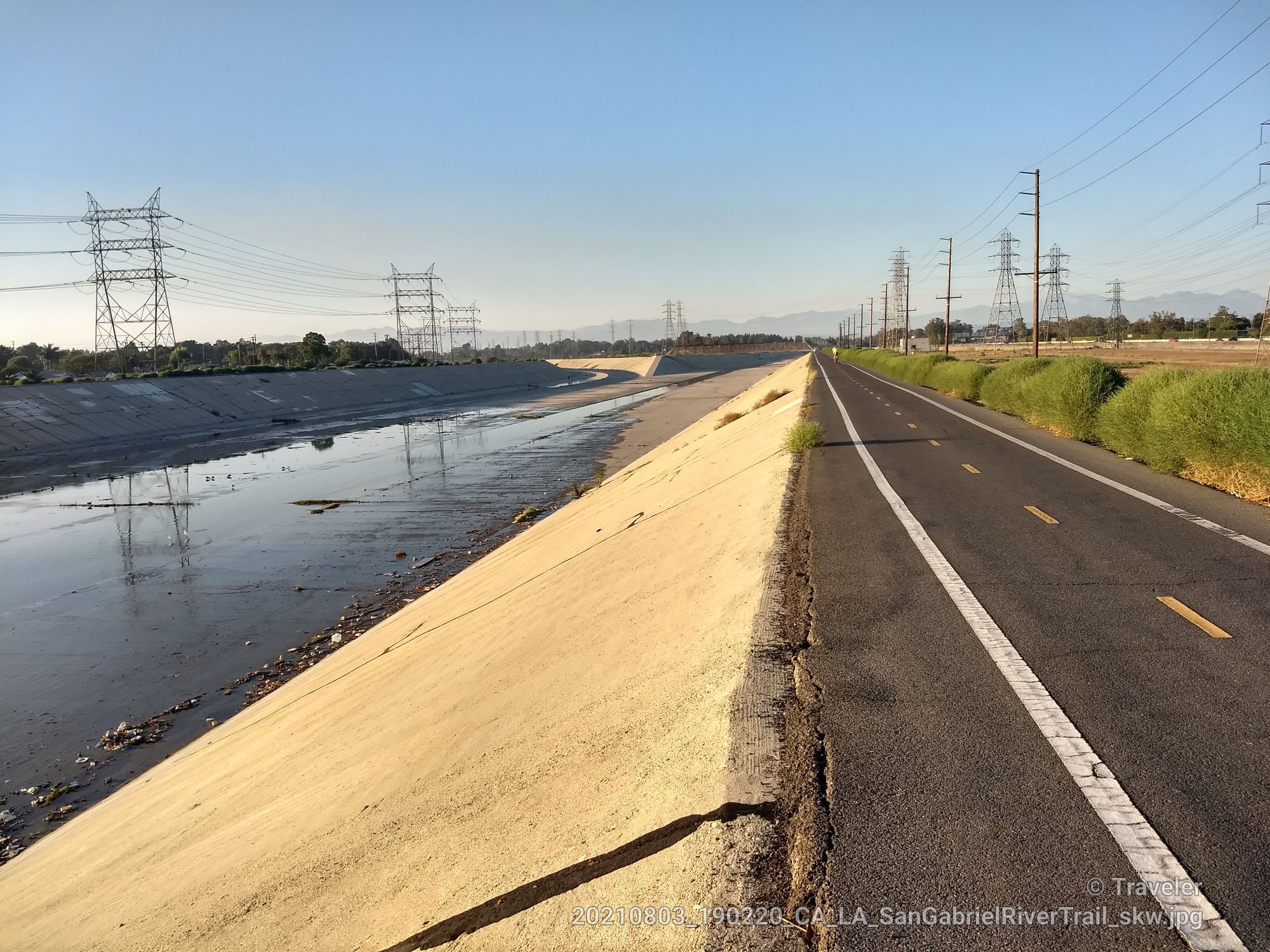 Concrete canal alongside a paved road, with power lines under a bright sky. - San Gabriel River Trail – San Gabriel River Trail loop from Hawaiian Gardens