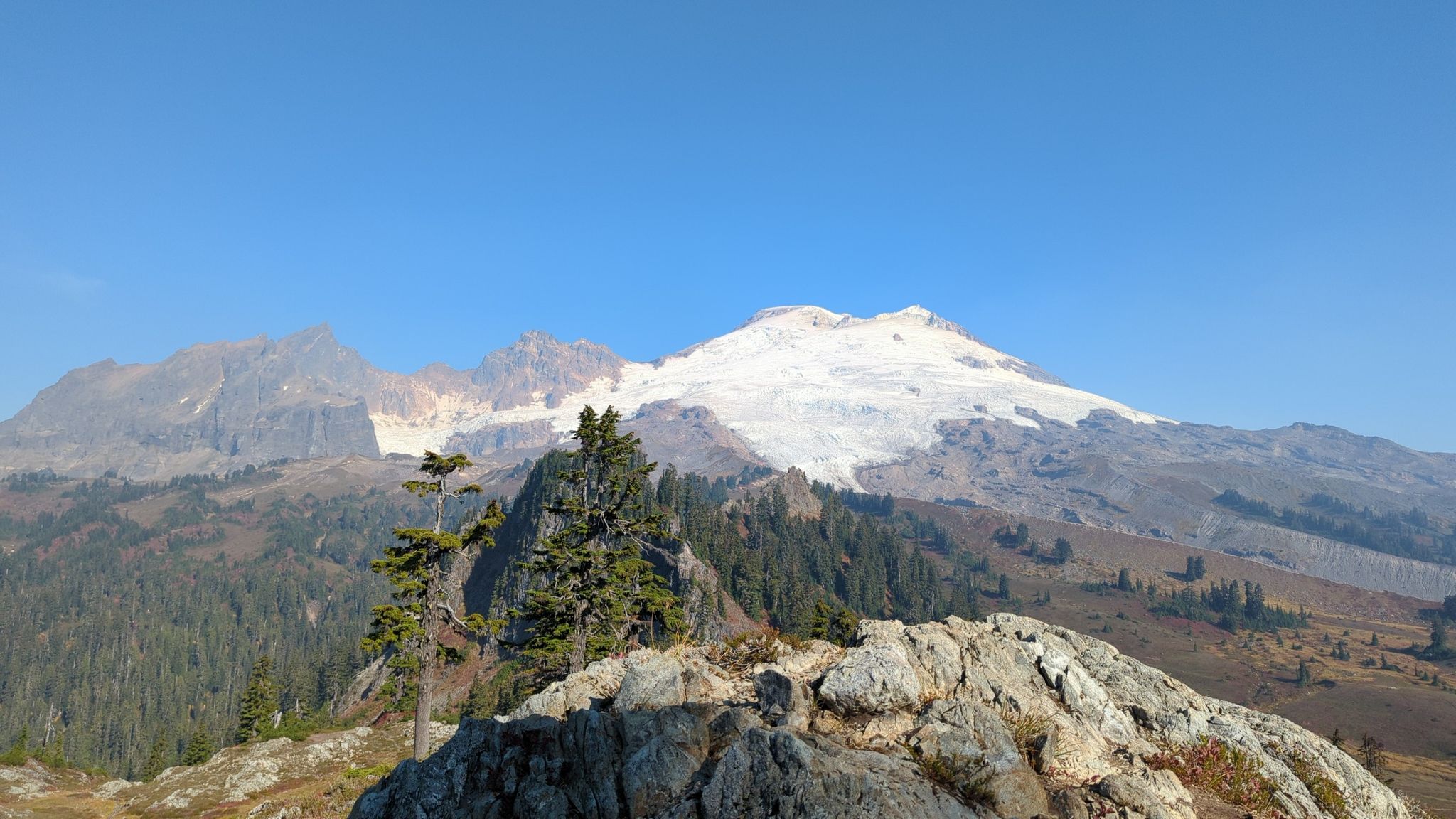 Rocky foreground with evergreen trees, overlooking a majestic snow-capped mountain. - Park Butte Lookout – Mazama Park shelter loop from Ridley Creek Trailhead
