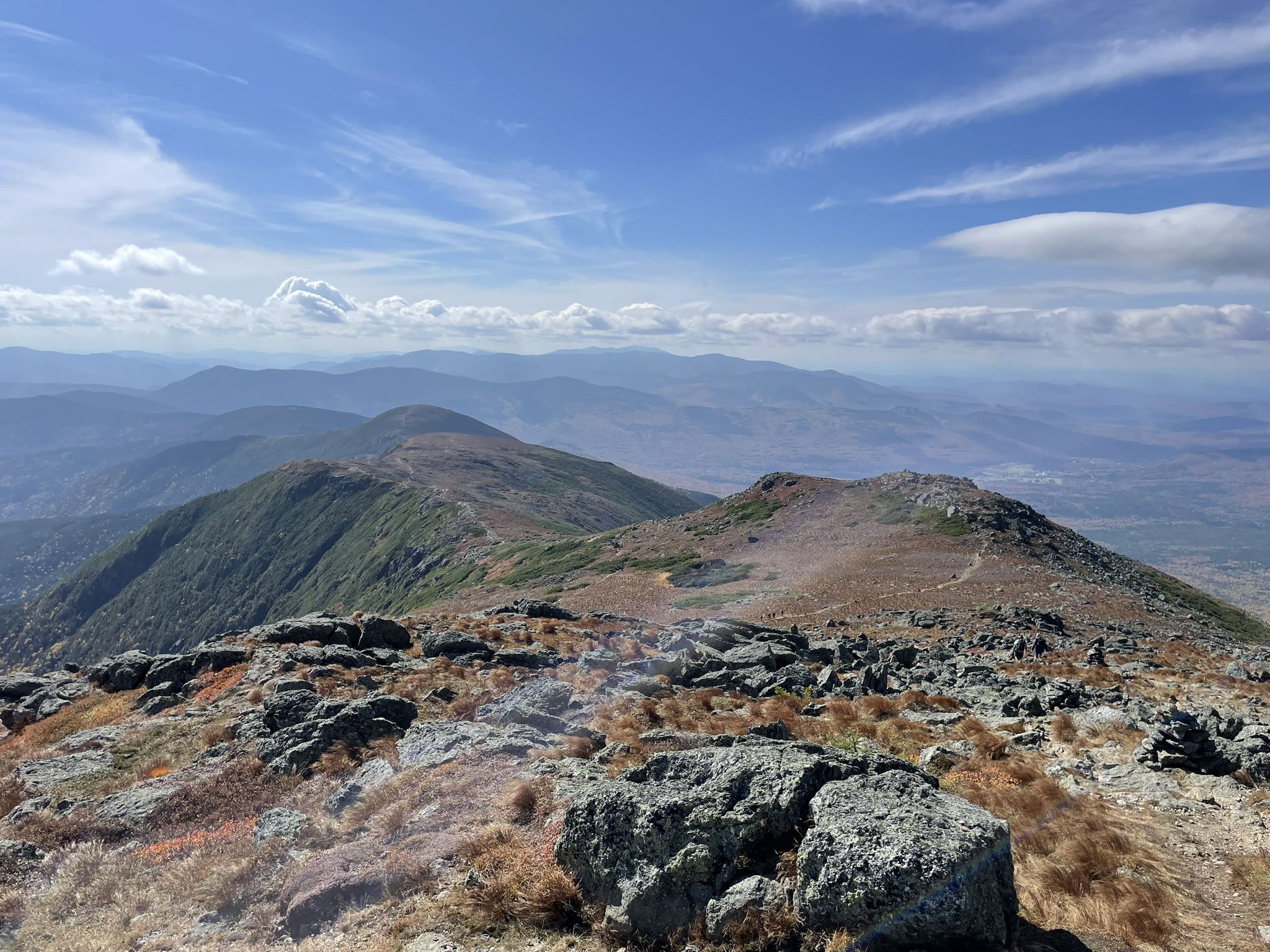 A rocky mountain ridge extends under a partly cloudy sky with distant peaks. - Crawford Path