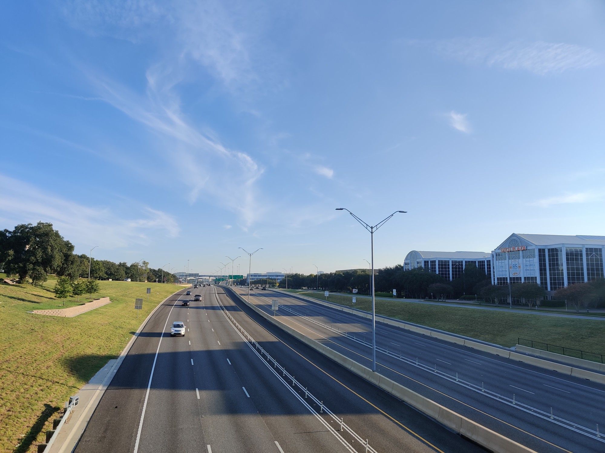 A multi-lane highway with light traffic under a clear blue sky. - Spanish Oak Creek Bridge – Rolling hills up to Round Rock loop from Cedar Park Austin Steam Train Association