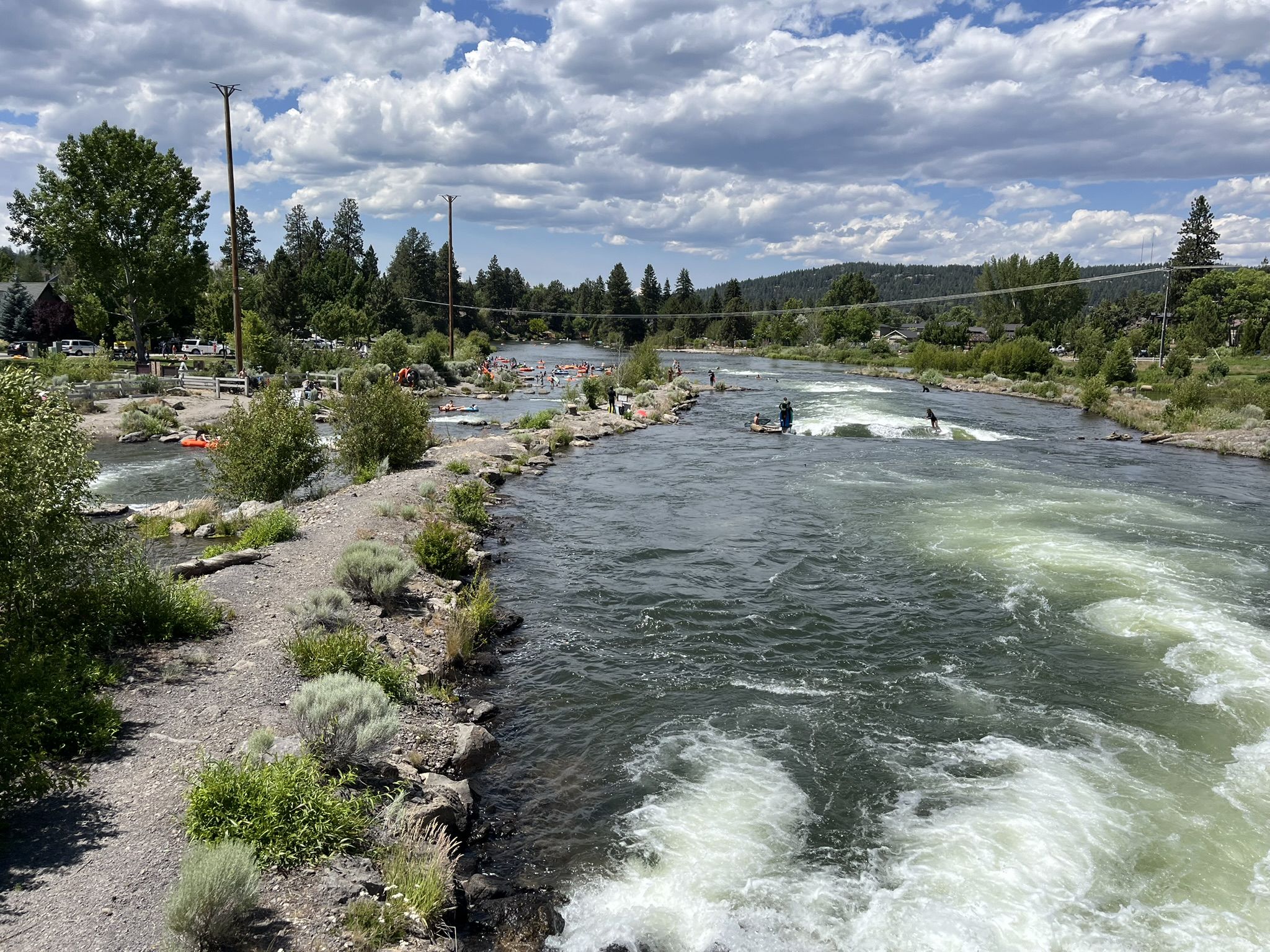 Kayakers navigate rapids on a wide river under a cloudy sky. - Farewell Bend Park – Drake Park loop from Deschutes Brewery