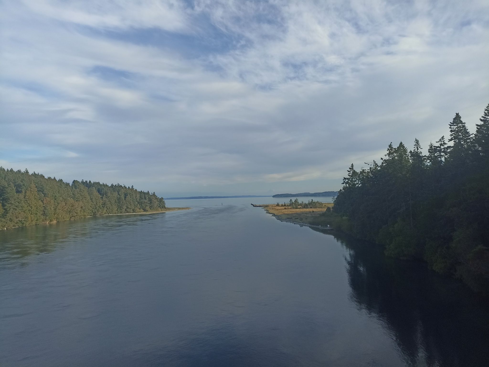 Wide water channel between forested shores under a cloudy sky. - Cape George Road – Fort Flagler State Park loop from Port Townsend