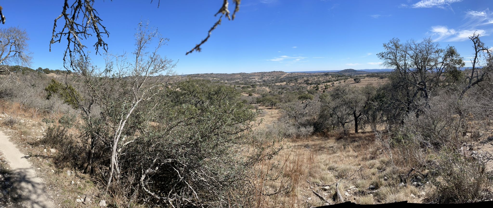 Panoramic view of a dry, hilly landscape with sparse trees under a clear sky. - Roadbike loop from Flat Rock Ranch