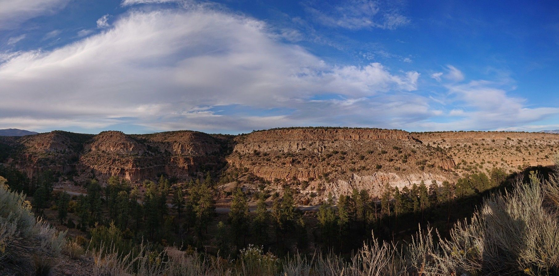 Panoramic view of a vast arid canyon with rocky cliffs under a bright sky. - Juniper Campground loop