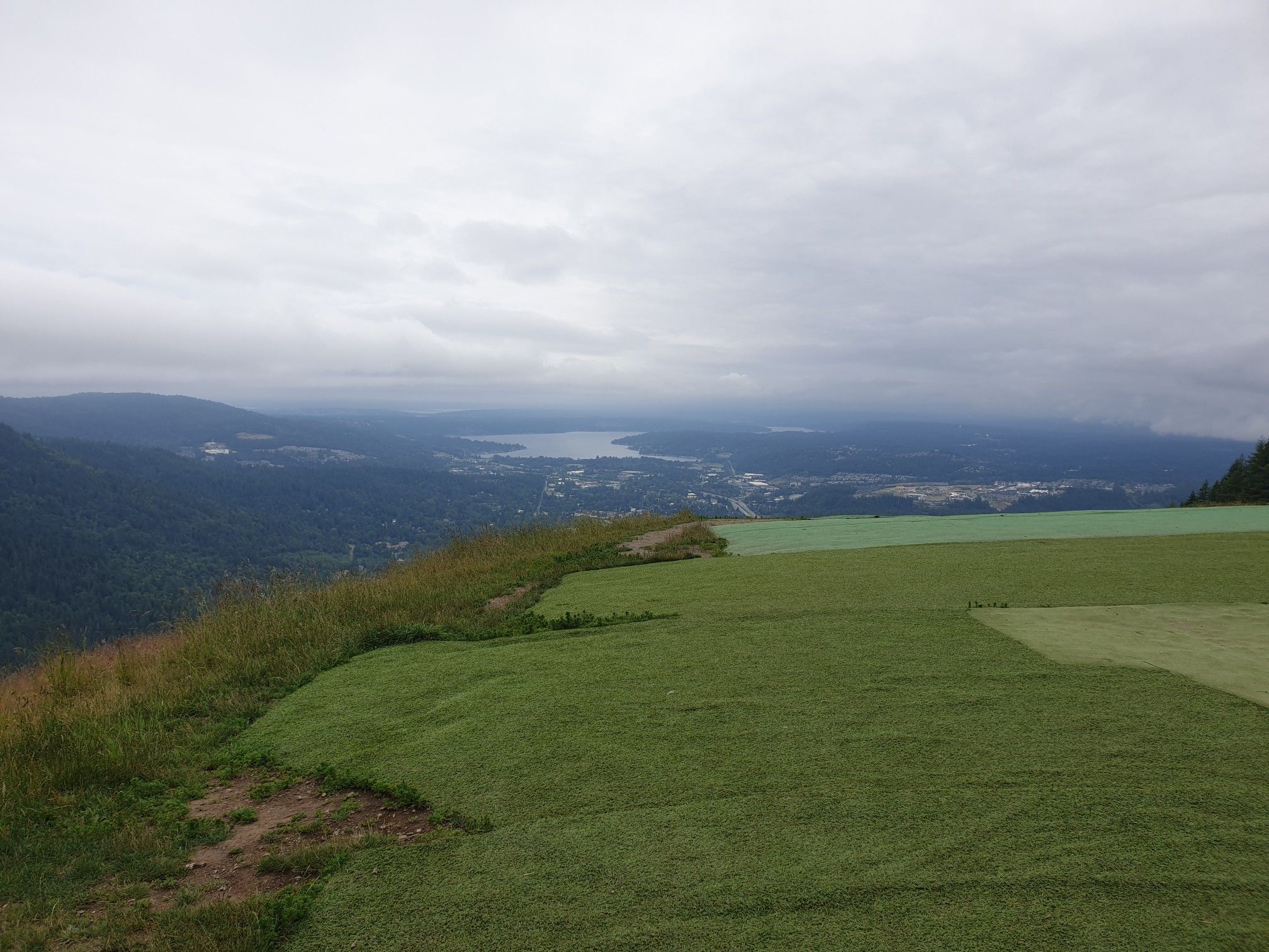 A wide view of a grassy mountain slope under a cloudy sky. - Poo Poo Point and Chirico Trail Loop