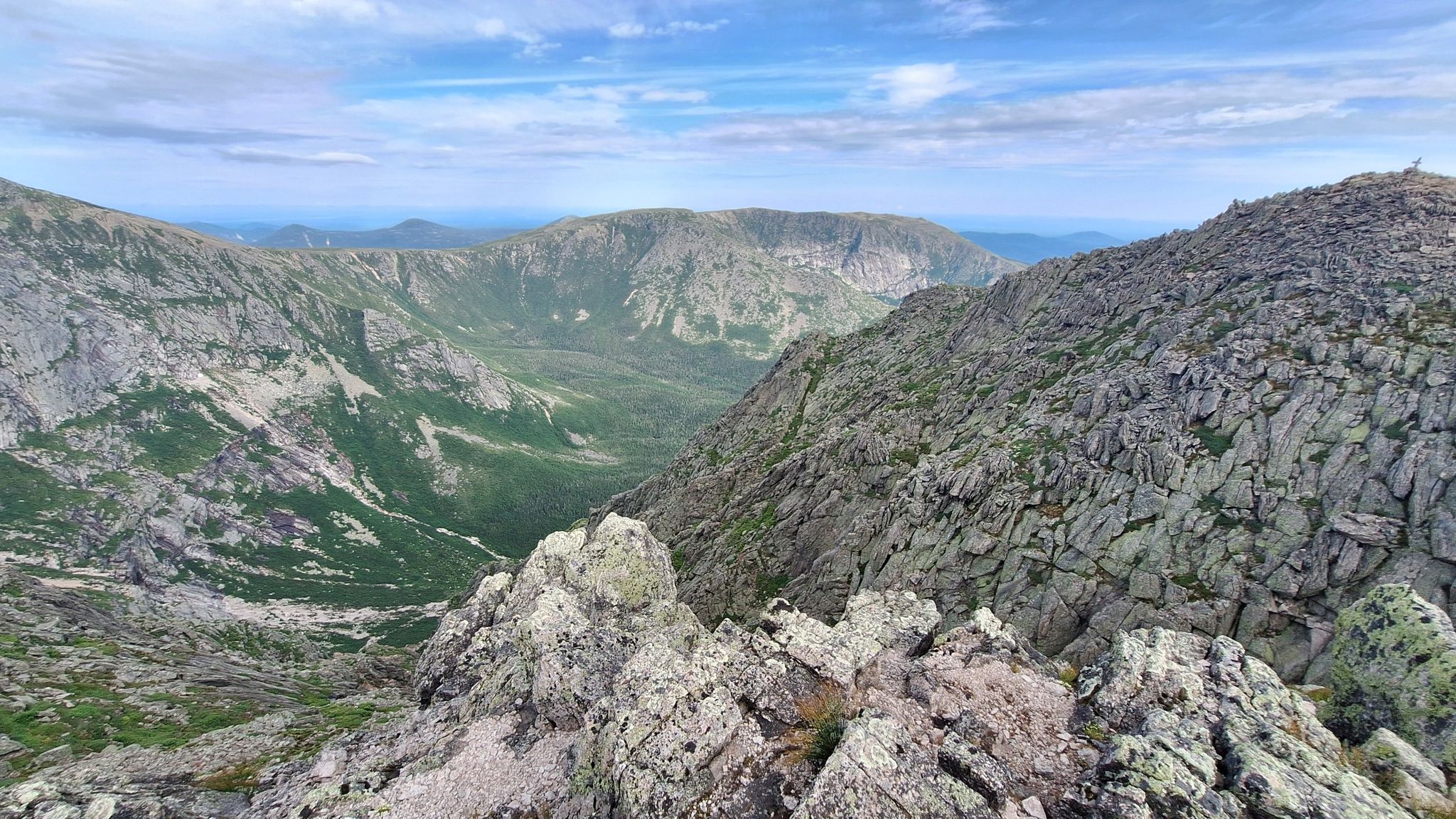 Rugged mountain peaks and a deep valley under a bright, partly cloudy sky. - Mount Katahdin via Hunt, Knife Edge, and Helon Taylor Trail Loop