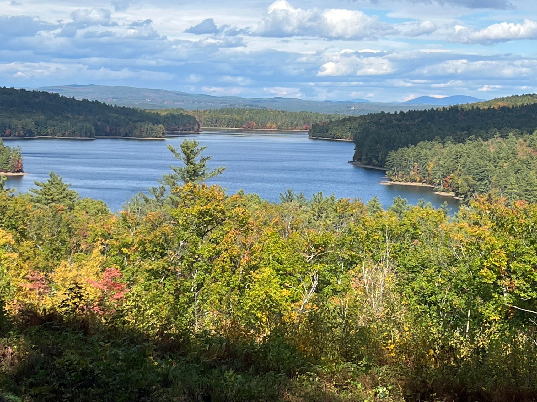 A scenic lake surrounded by vibrant autumn trees under a cloudy sky. - Jerry Hill loop from Saint Pauls School
