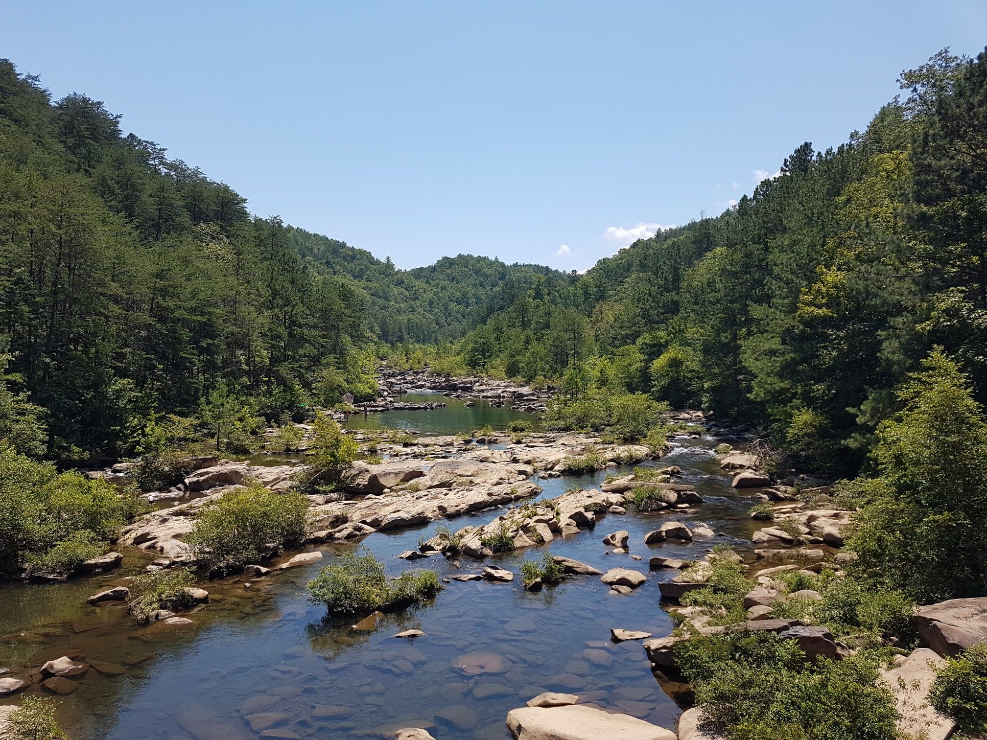 A rocky river flows through a green forested valley under a clear sky. - Whitewater River – Ocoee Number Three loop from Ocoee Number Three Lake