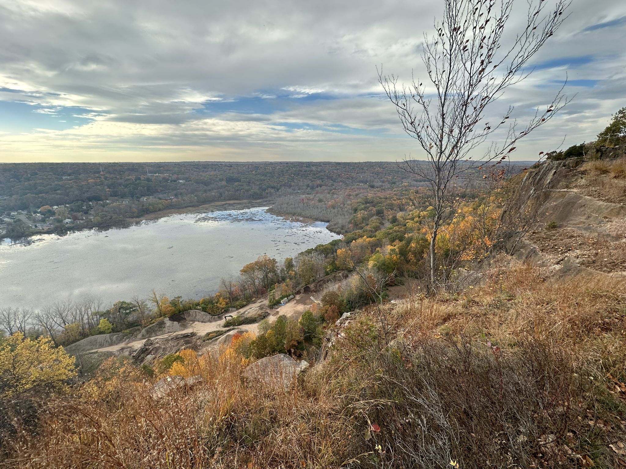 Overlook of a wide river and autumn forest under a cloudy sky. - Climb Baldwin Drive – West Rock Ridge State Park loop from Yale Bowl