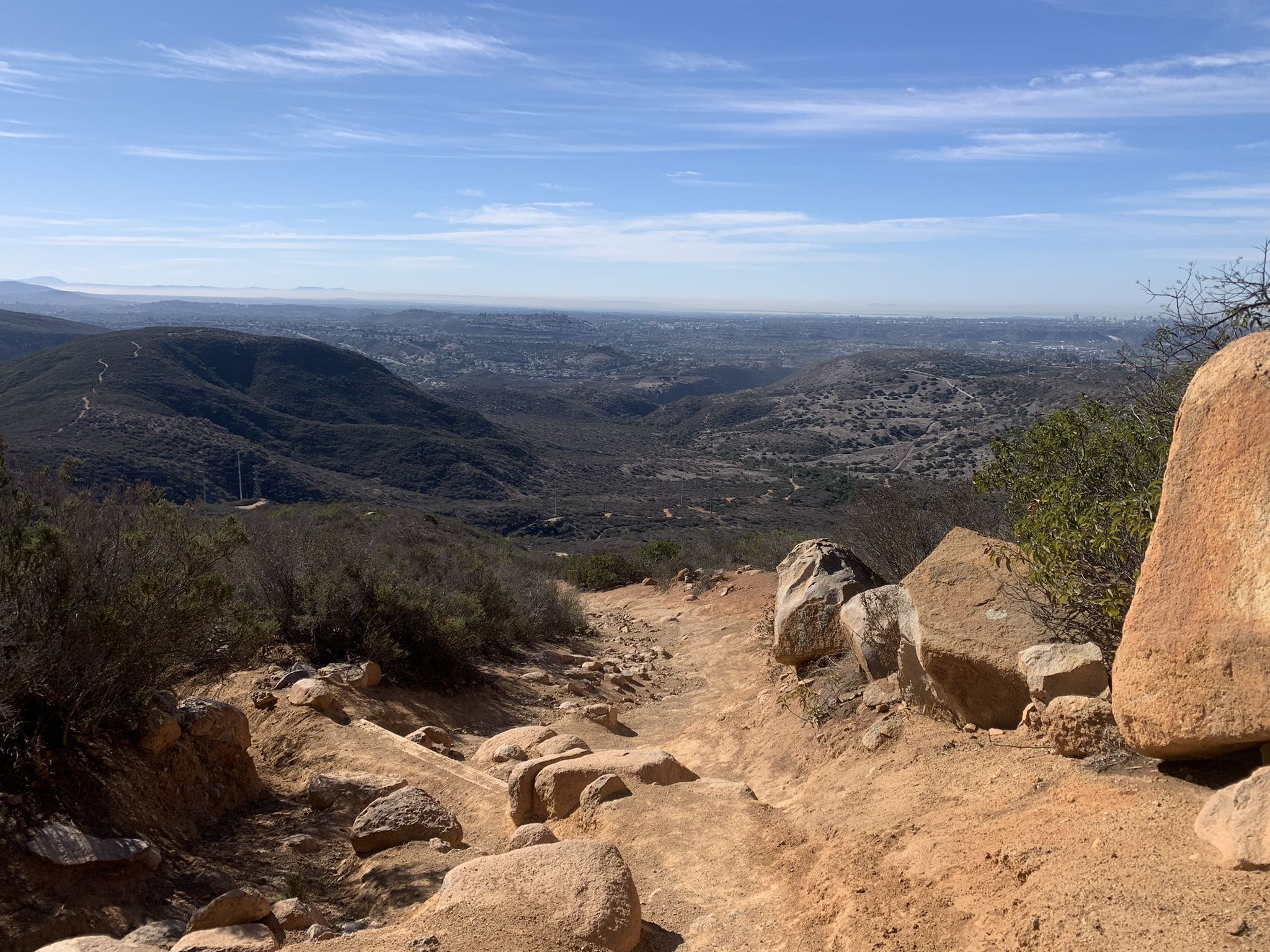 Rocky dirt path descending into a vast valley under a clear blue sky. - North Fortuna Summit – North Fortuna Geodesic Vertex loop from West Fortuna Staging Area