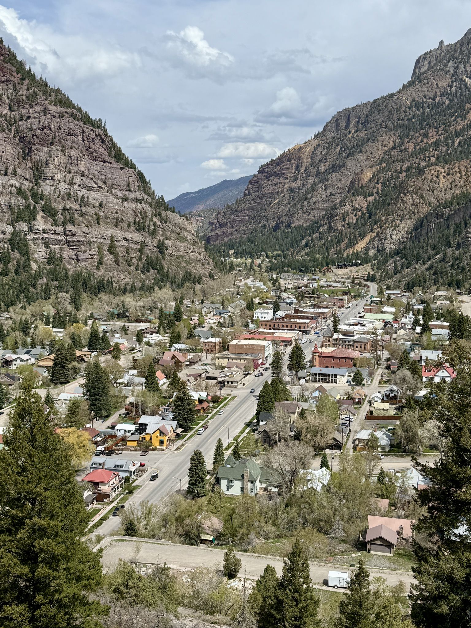 An aerial view of a town nestled in a mountain valley on a bright day. - Red Mountain Pass – Ouray loop from Large Vehicle Parking