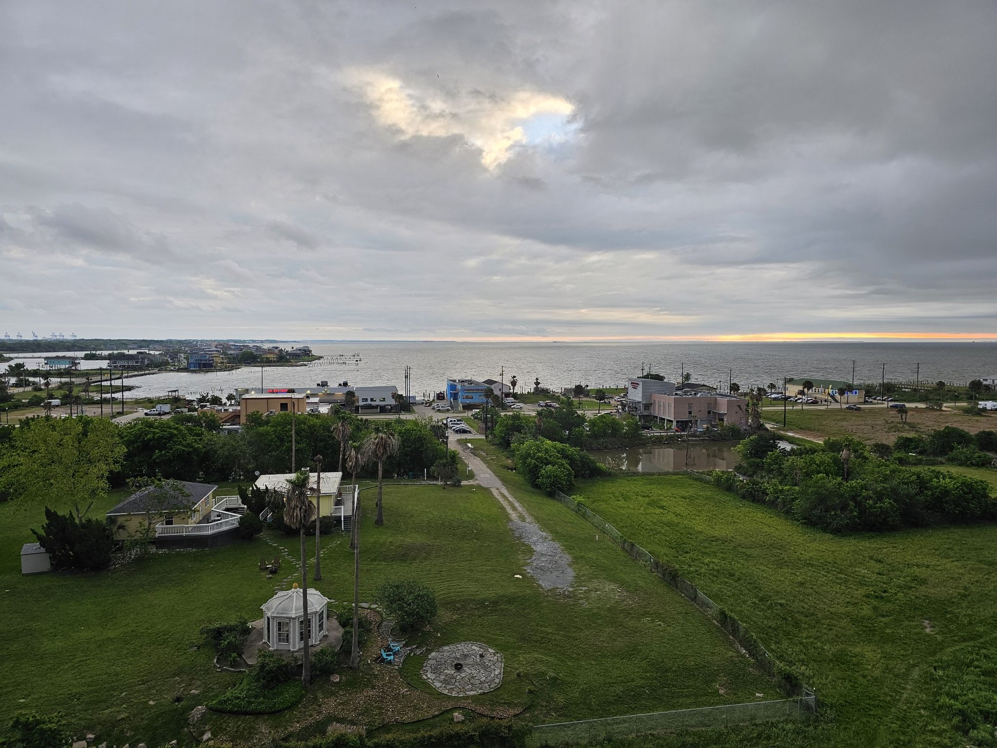 Aerial view of a coastal town with houses and water under an overcast sky. - Kemah Boardwalk – View of the Bay loop from Seabrook