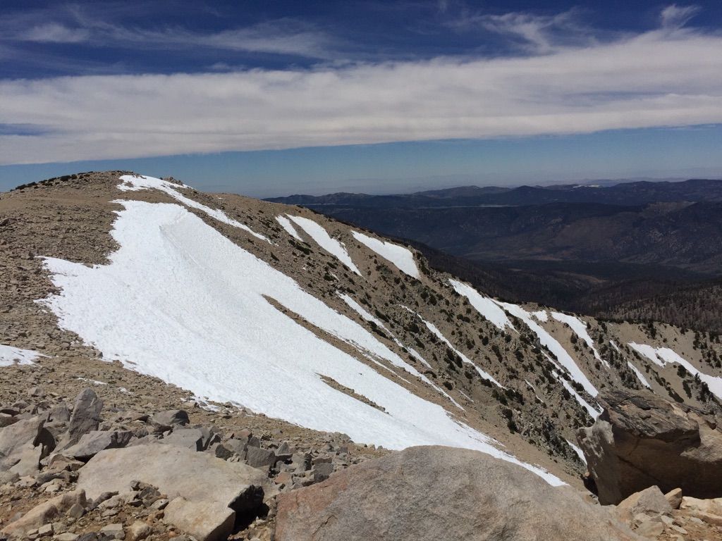 Rocky mountain peak with patches of snow under a partly cloudy sky. - San Gorgonio Mountain via Fish Creek Trail