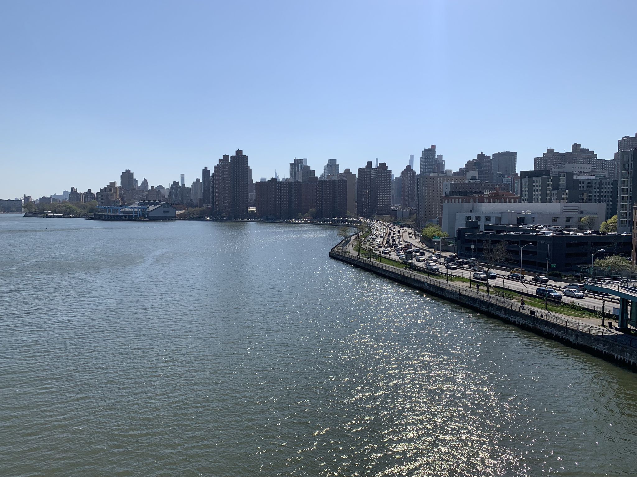 River with city skyline and busy highway under bright sun. - East River and Randalls Island Greenway Loop