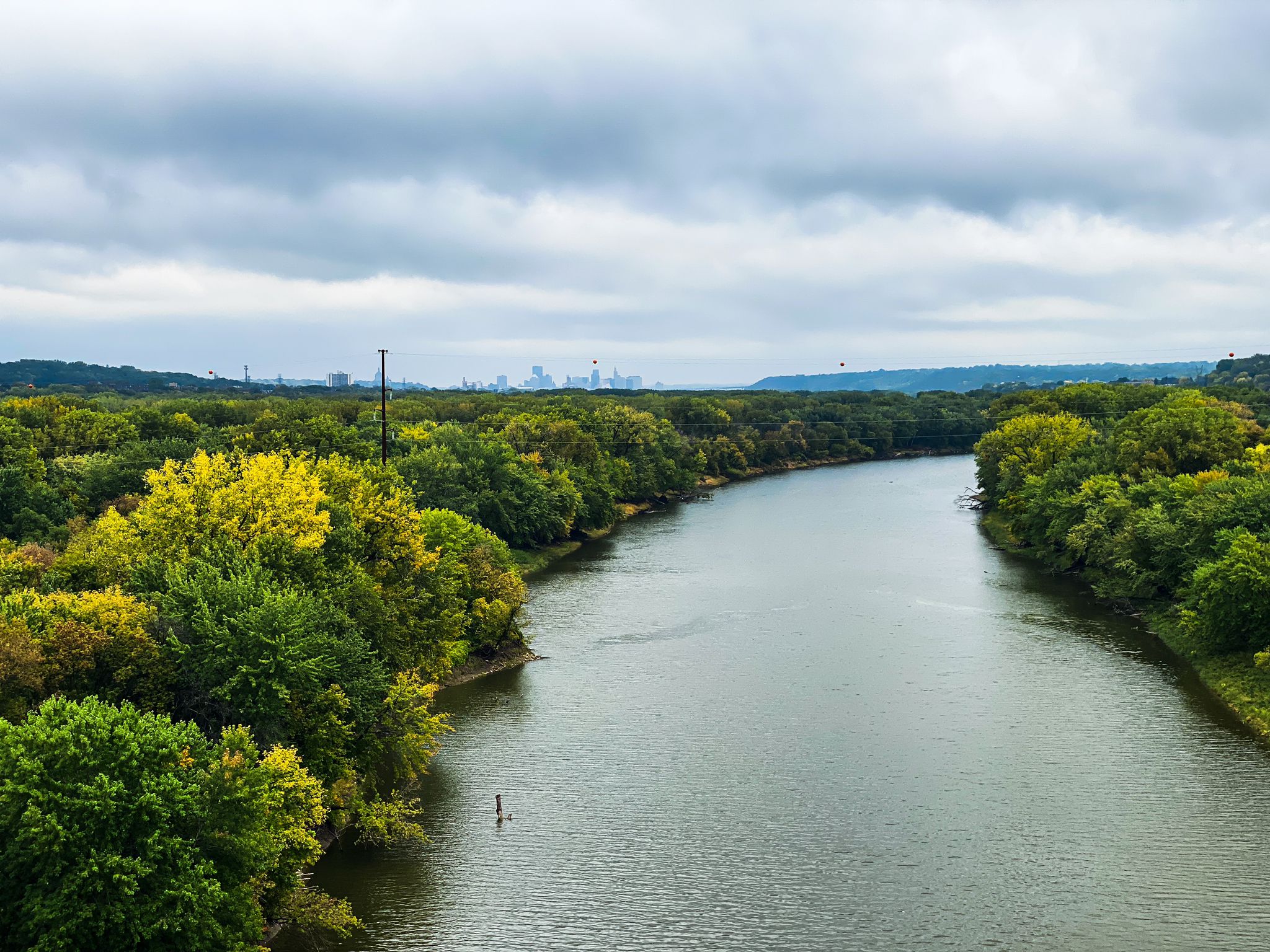 River winding through dense green and yellow forests under a cloudy sky. - Mendota Bridge – Pickerel Lake loop from Raymond Avenue