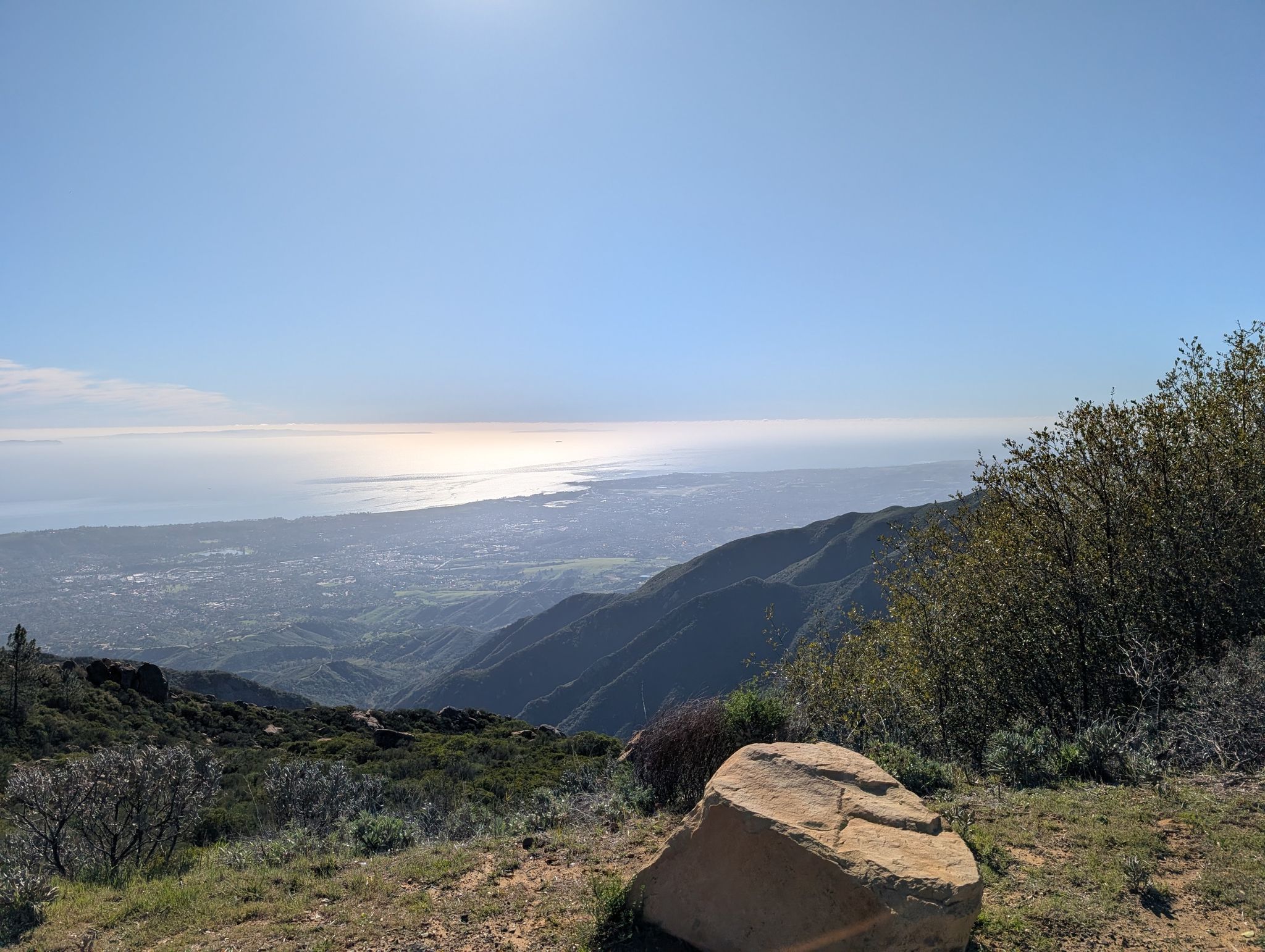 Sunny panoramic view of green mountains, a valley, and a distant ocean. - La Cumbre Peak loop from Chumash Painted Cave State Historic Park