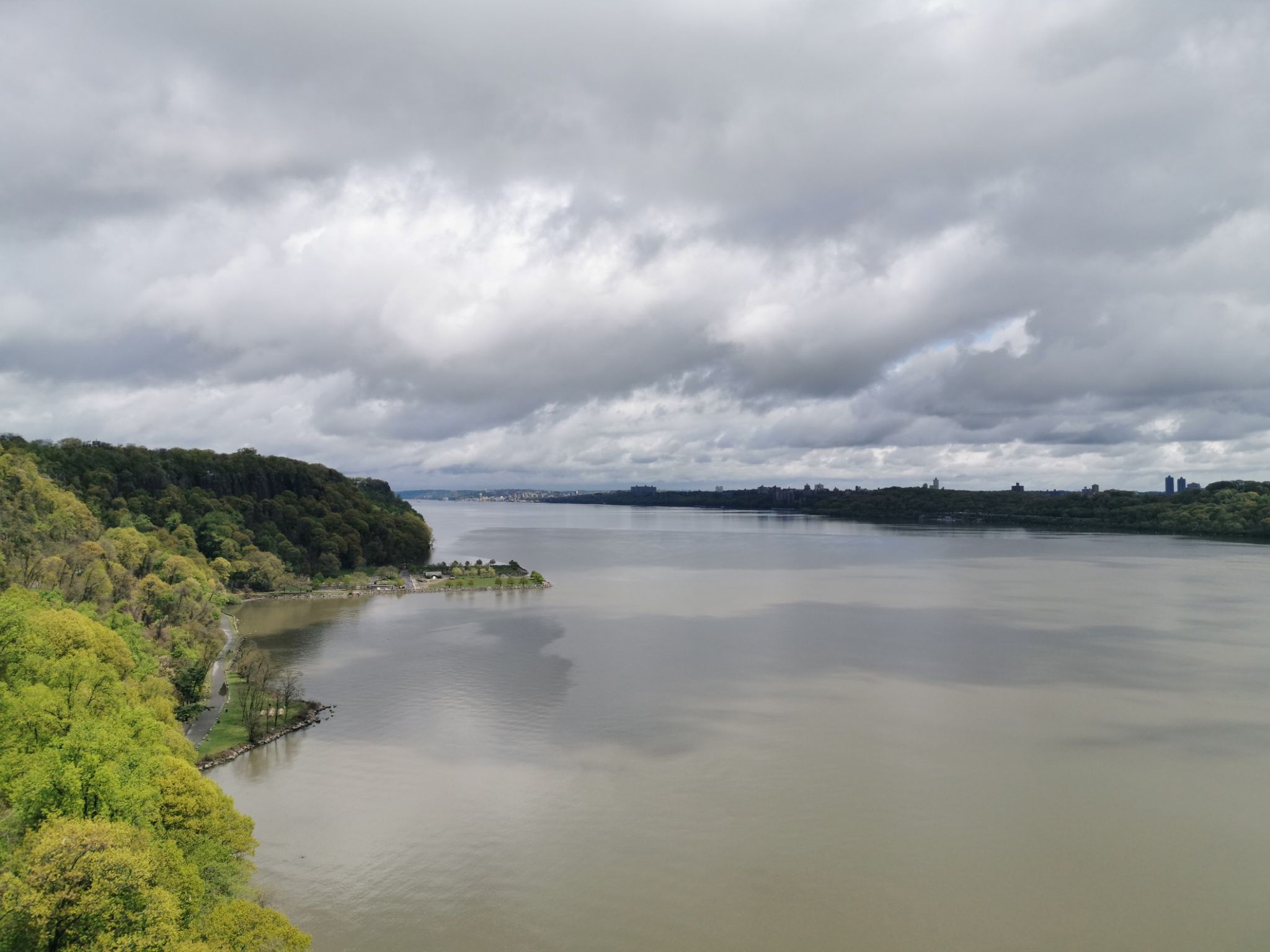 Wide river with lush green banks under an overcast sky. - Tappan Loop