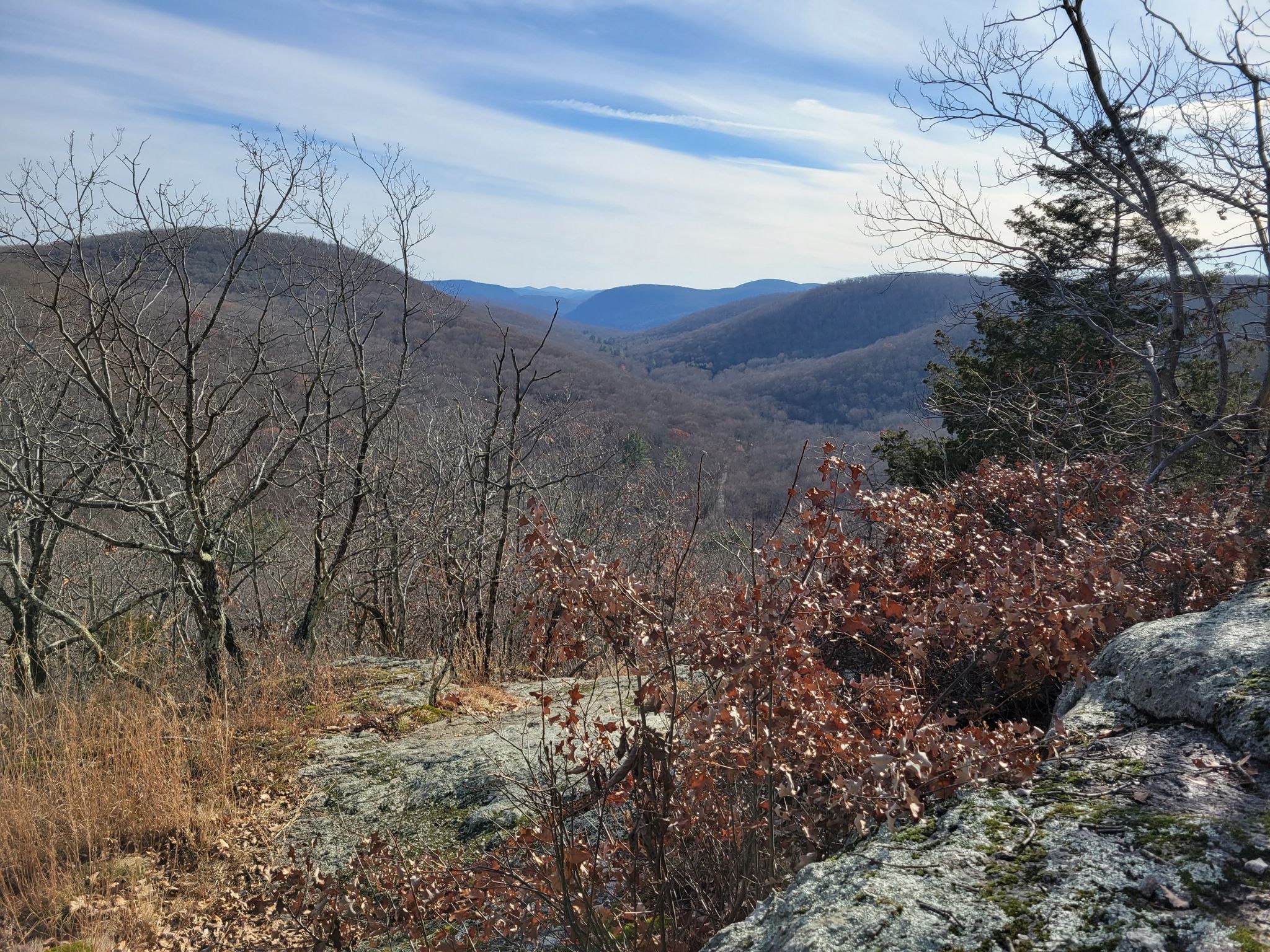 Panoramic view of rolling, bare hills under a bright, partly cloudy sky. - Macedonia Ridge Trail
