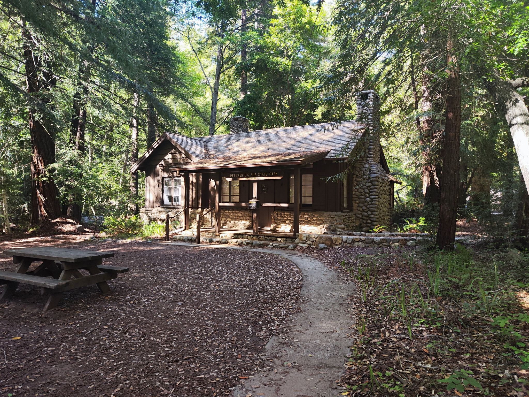 Rustic cabin with a stone chimney nestled in a dense forest. - Big Sur River loop from Pfeiffer Big Sur State Park