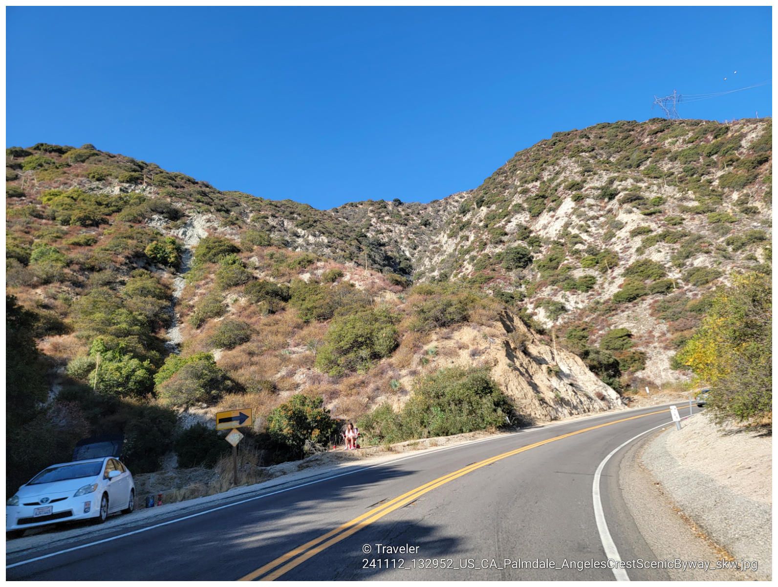 Curved mountain road with a parked white car, flanked by dry, brush-covered hills. - Clear Creek Vista loop from Saint Francis High School