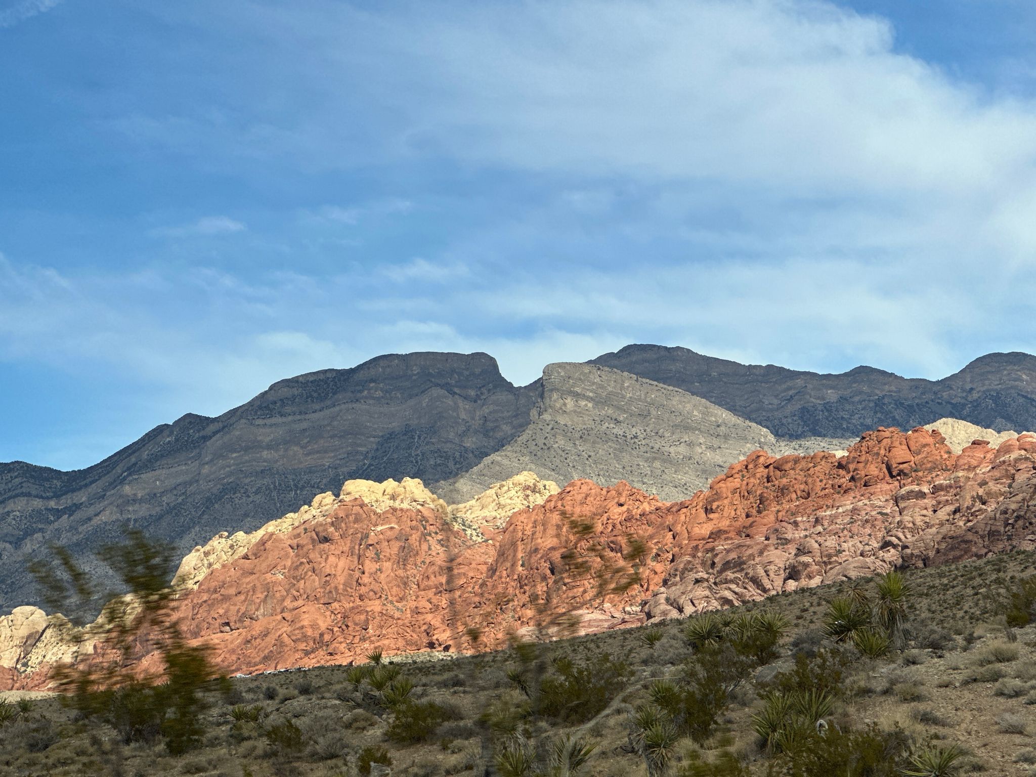 Colorful desert mountains under a bright sky with sparse foreground vegetation. - Cowboy Trails Parking Lot – Red Rock Canyon Overlook loop from Summerlin South