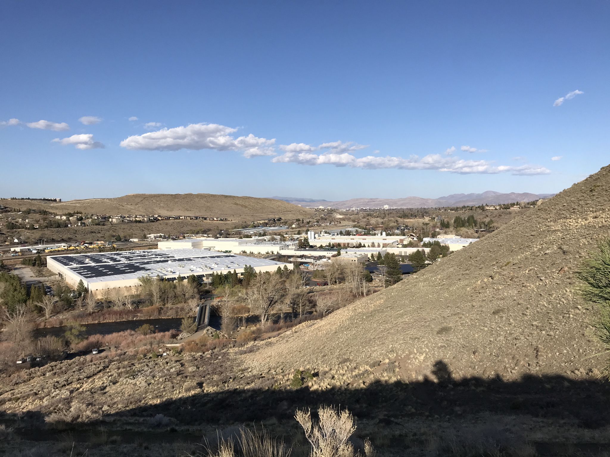 Overlook of industrial buildings in a valley surrounded by dry hills. - Tom Cooke and Steamboat Ditch Loop