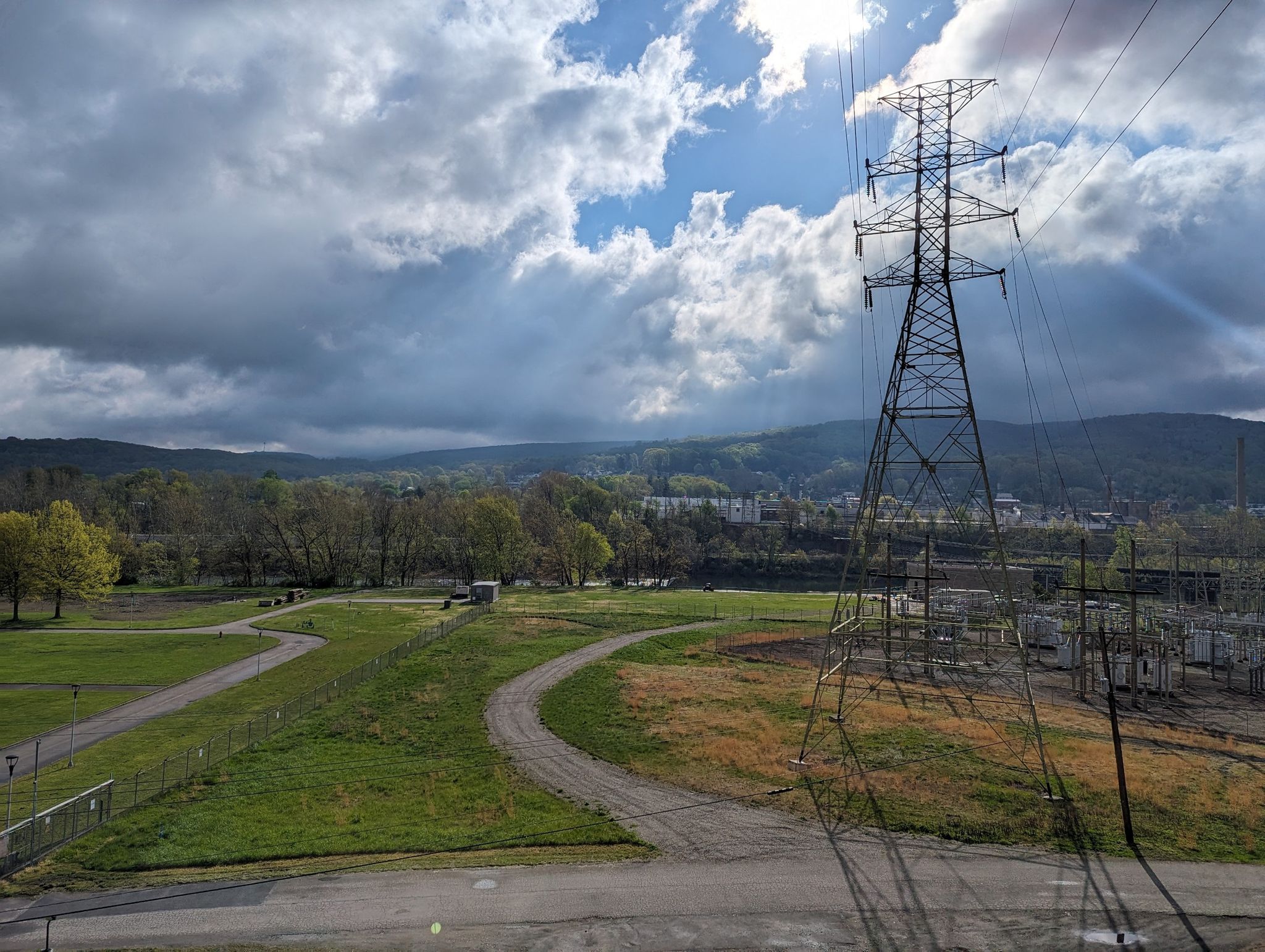 Power lines and tower in a green valley under a dramatic cloudy sky. - Sheepskin Trail loop
