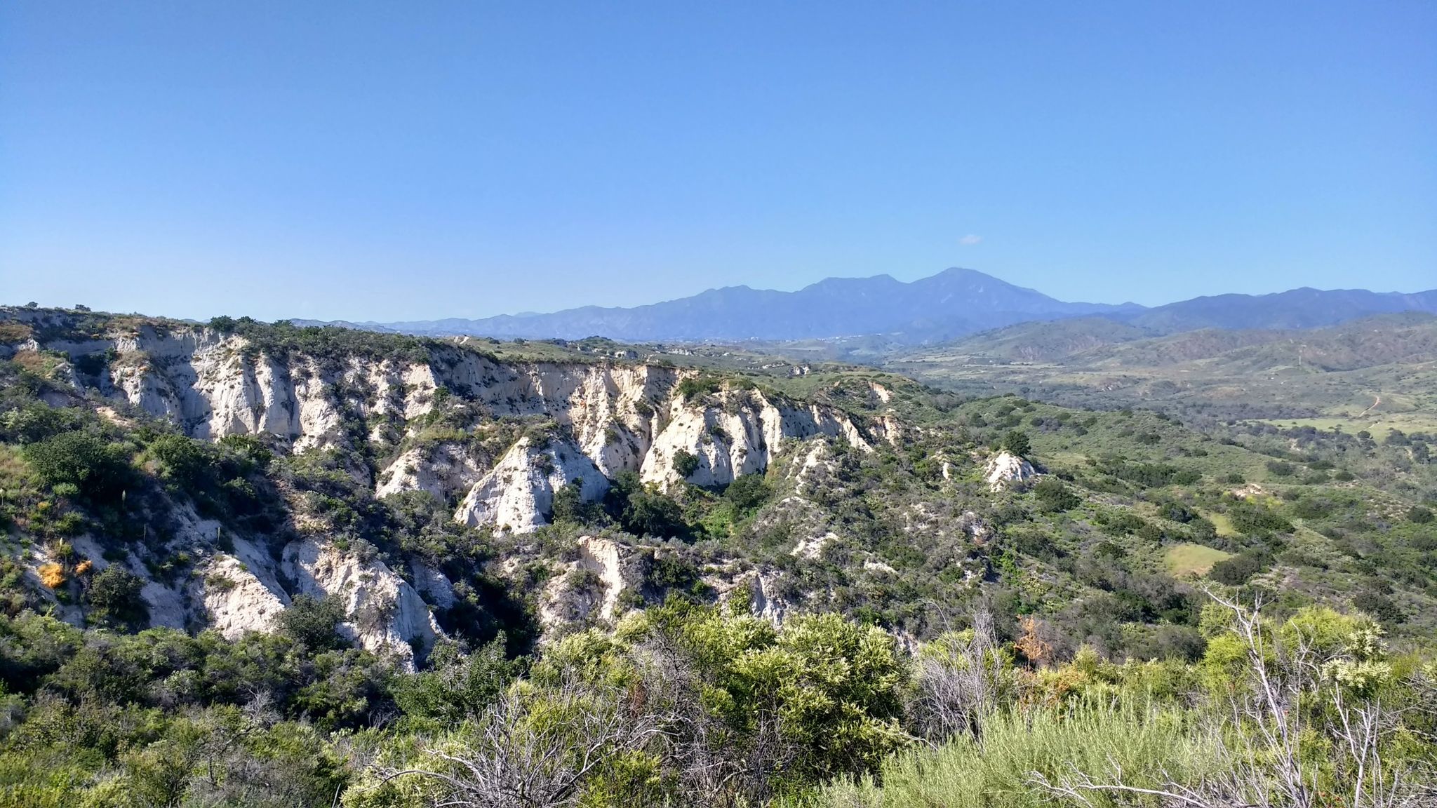 White rock cliffs and green hills under a clear blue sky. - Bell Canyon, West Ridge, and Loskorn Trail Loop