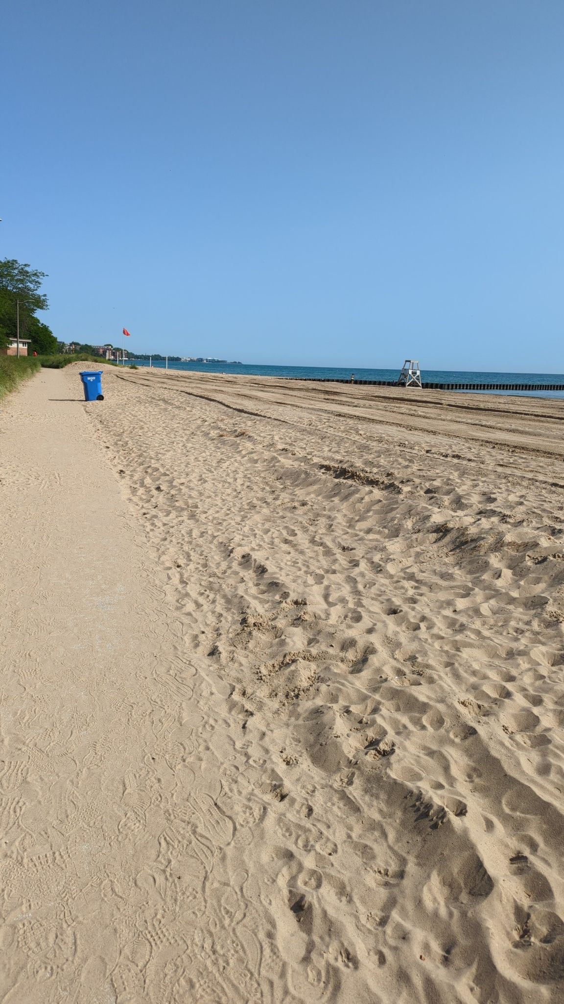 Wide sandy beach with a path, calm water, and clear blue sky. - Leone and Loyola Loop