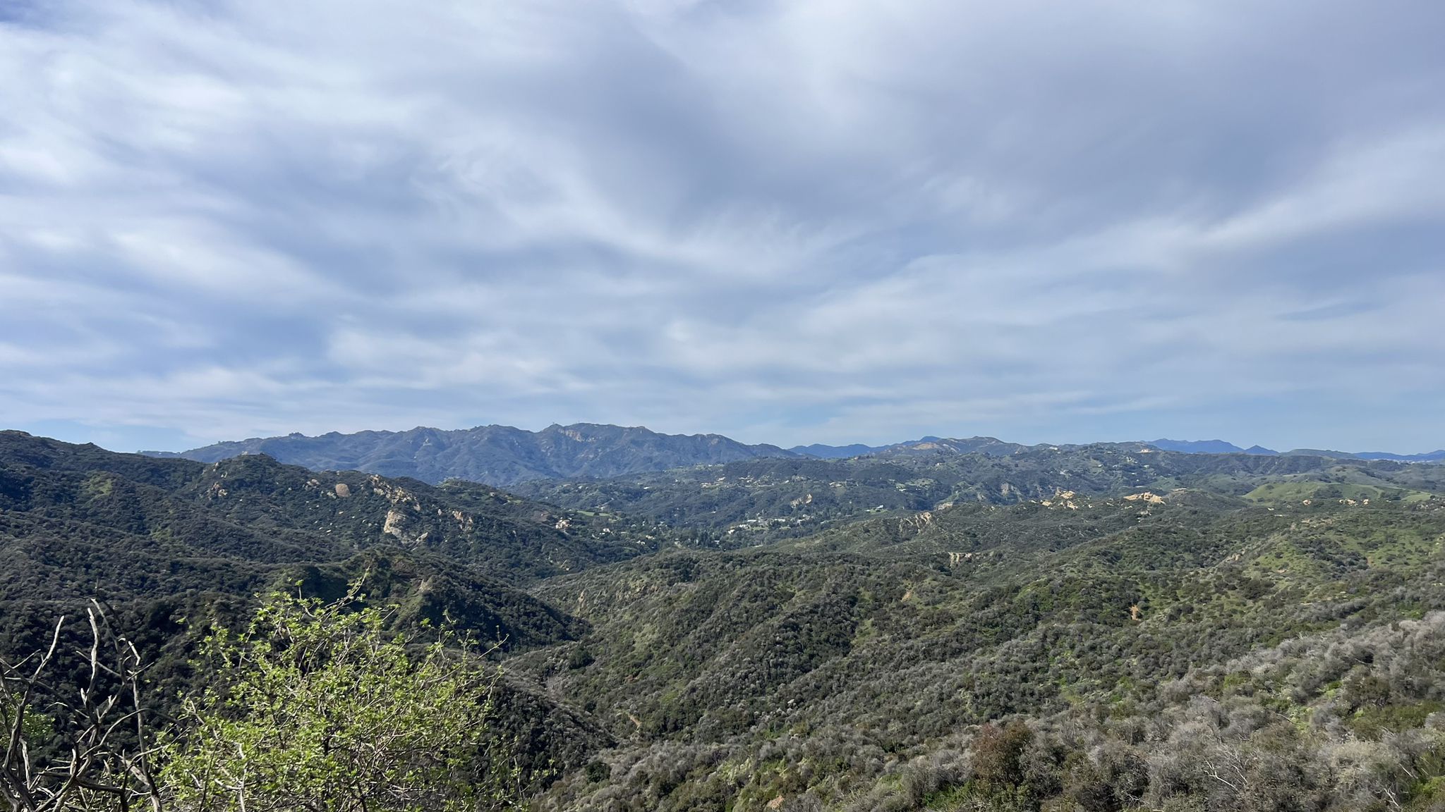 Vast mountain range with green hills under a cloudy sky. - Vanalden Cave – The Hub (Topanga State Park) loop from Woodland Hills