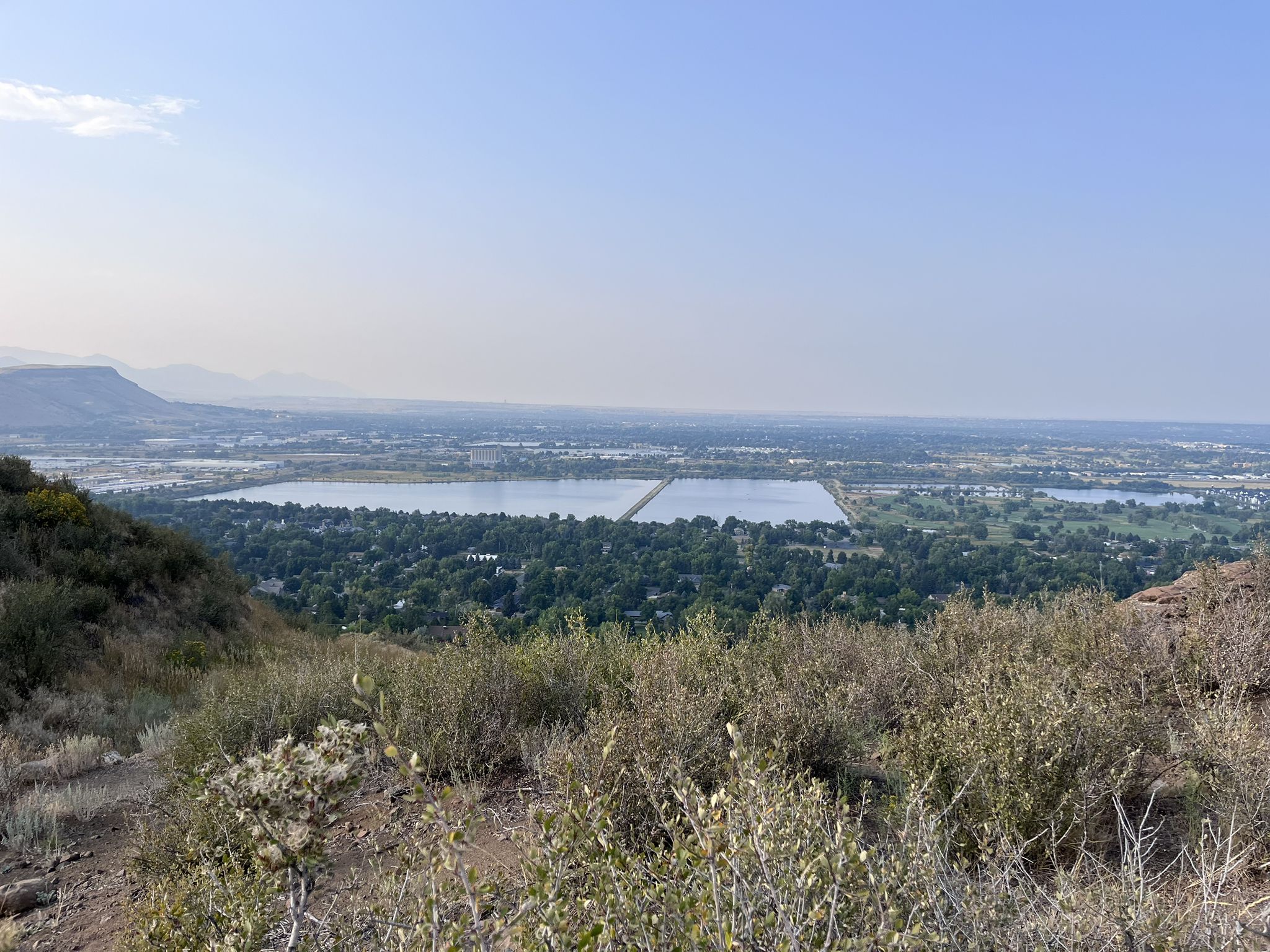 Elevated view of a valley with large water bodies and distant urban development. - Ancient Palms and Basalt Cap Loop