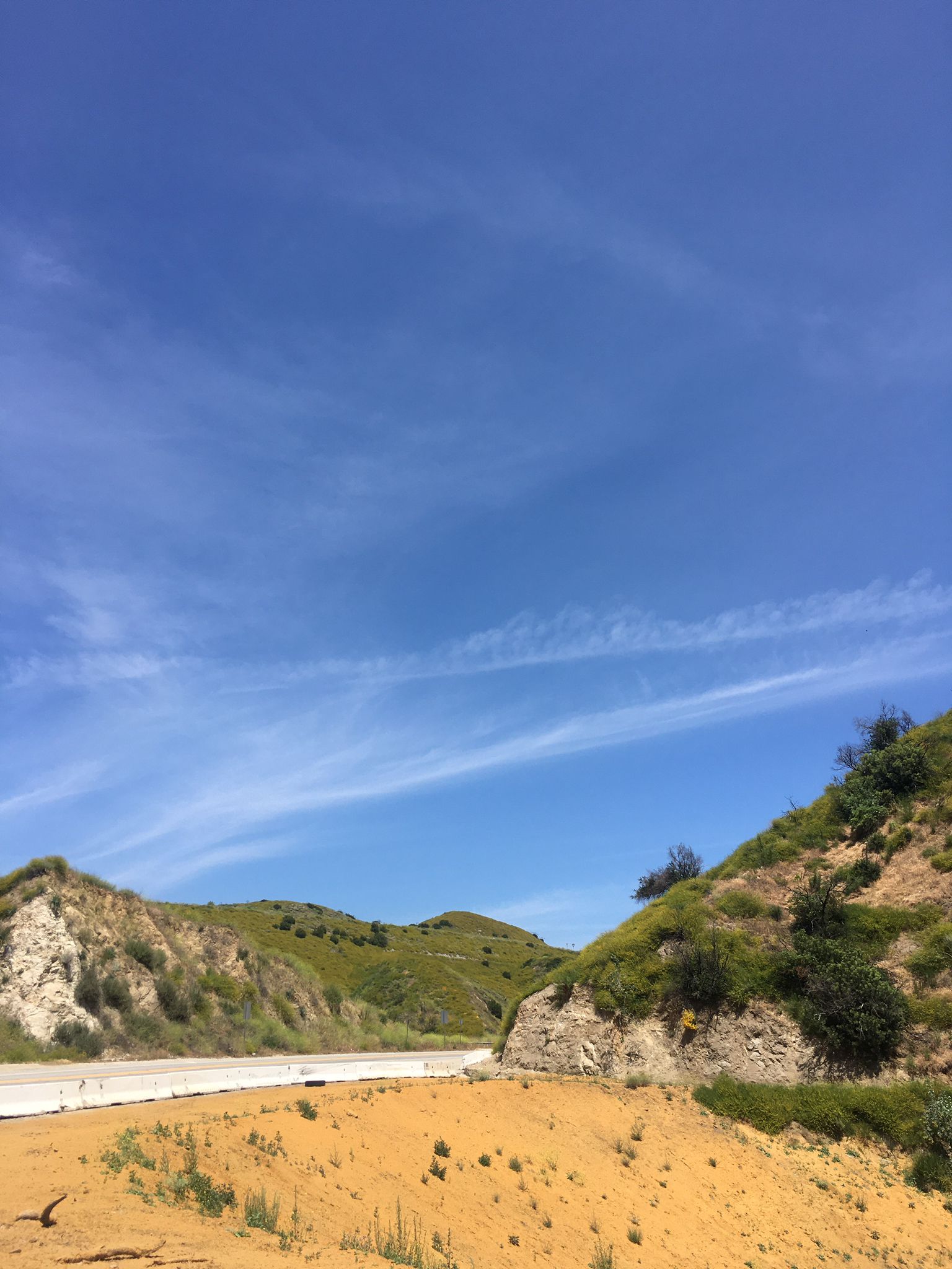 Paved road winding through arid, green hills under a bright blue sky. - La Tuna Canyon to Verdugo Peak Loop