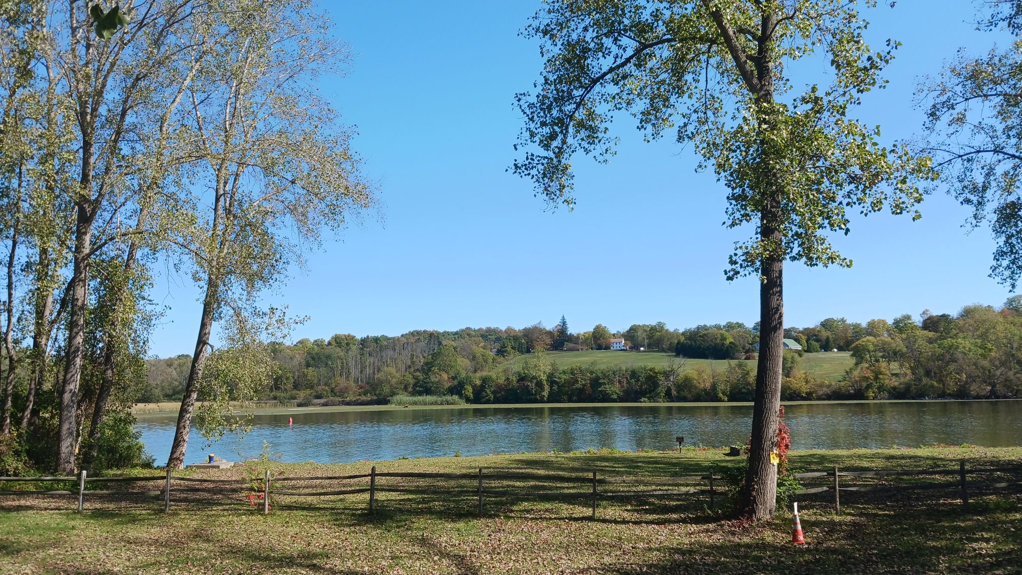 Sunny view of a calm lake with distant forested hills and scattered trees. - Johnstown to St. Johnsville loop