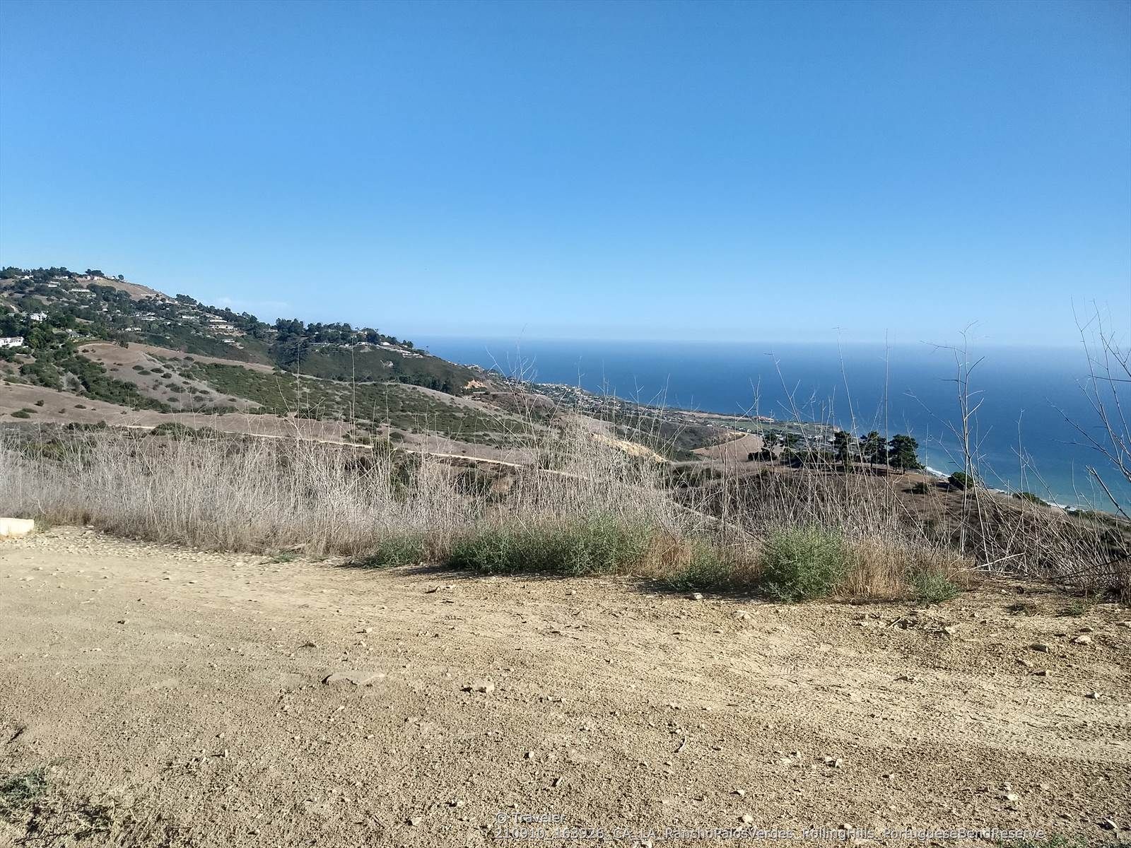 Expansive view of dry hills and a vast blue ocean under clear skies. - Burma Road and Eagle's Nest Loop